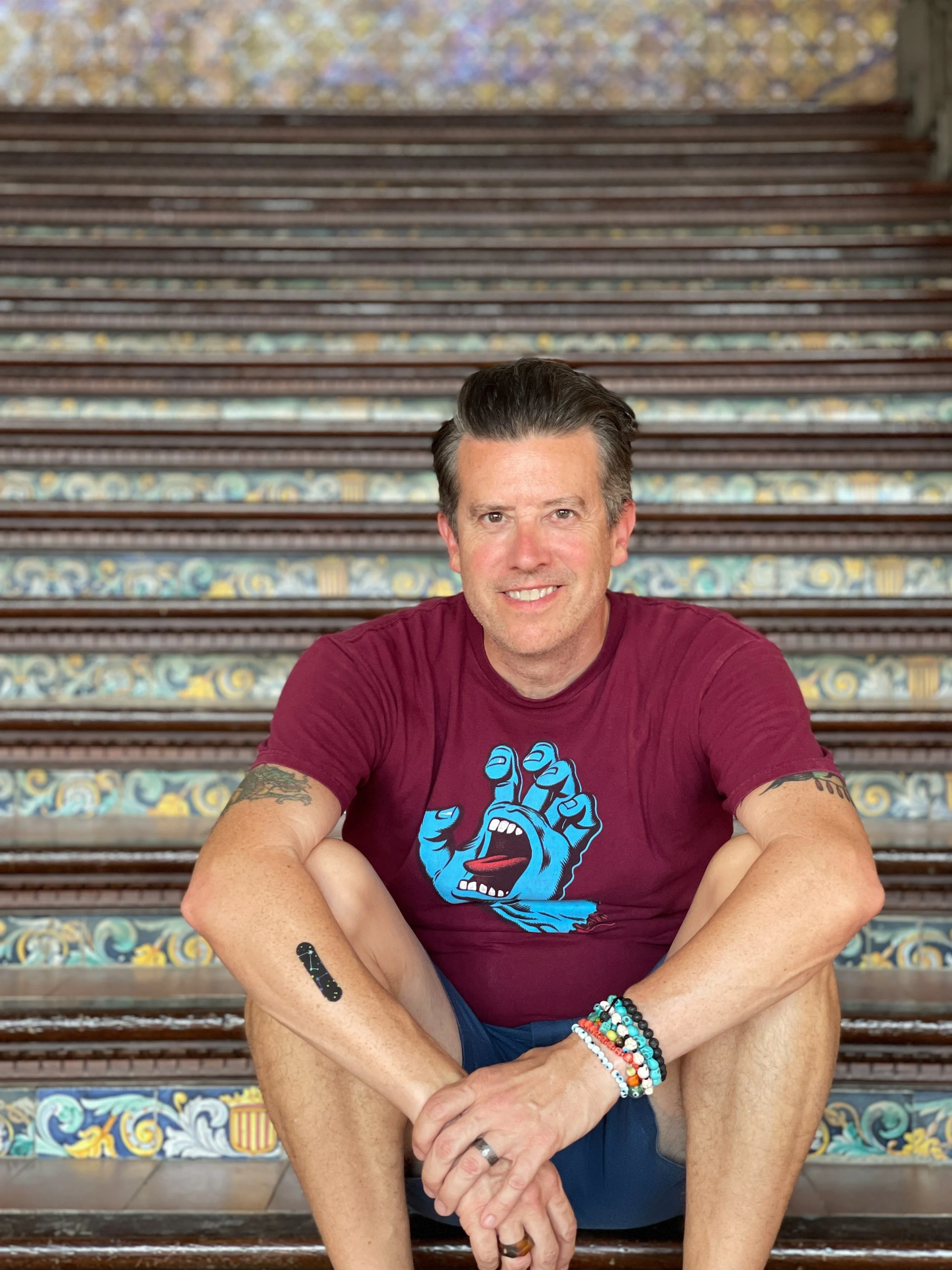 Man sits on tile-covered steps in the Plaza de España