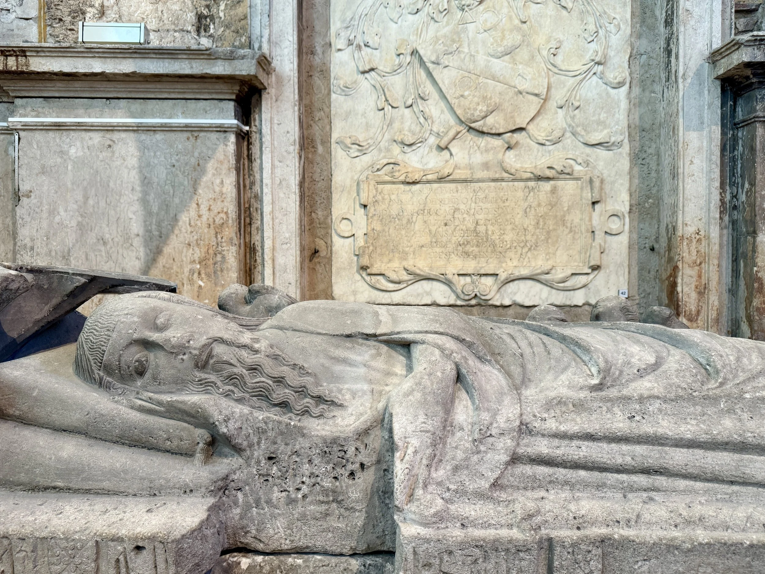 Recumbent figure of Fernão Sanchez, the illegitimate son of King Dinis, shown resting his head on a decorated pillow in the Carmo Convent museum