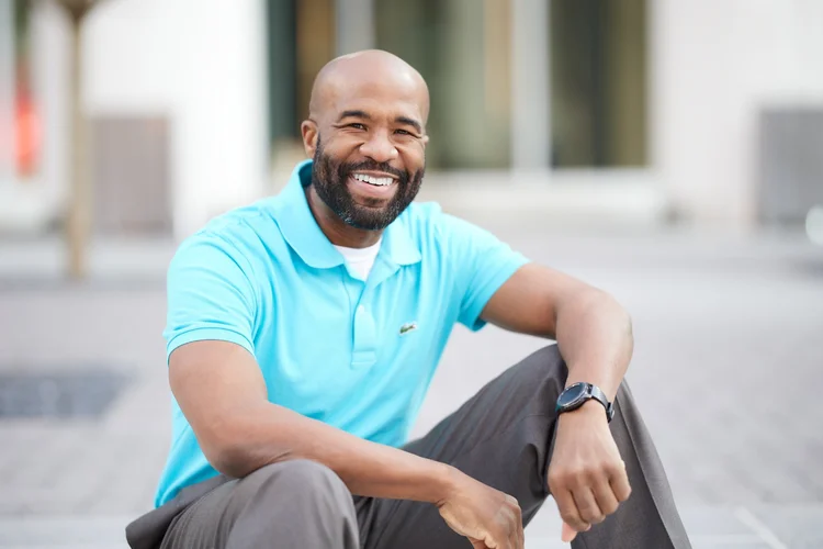 Charlotte outdoor headshot of a smiling professional with a beard in a light blue button-down by mjwphoto