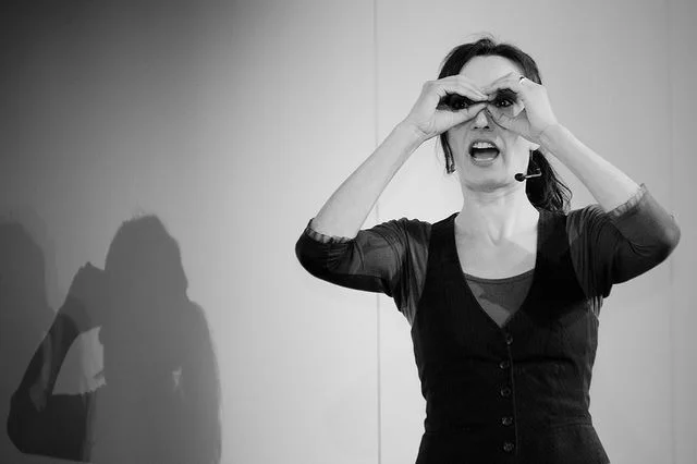  Improv actor with hands up as binoculars 