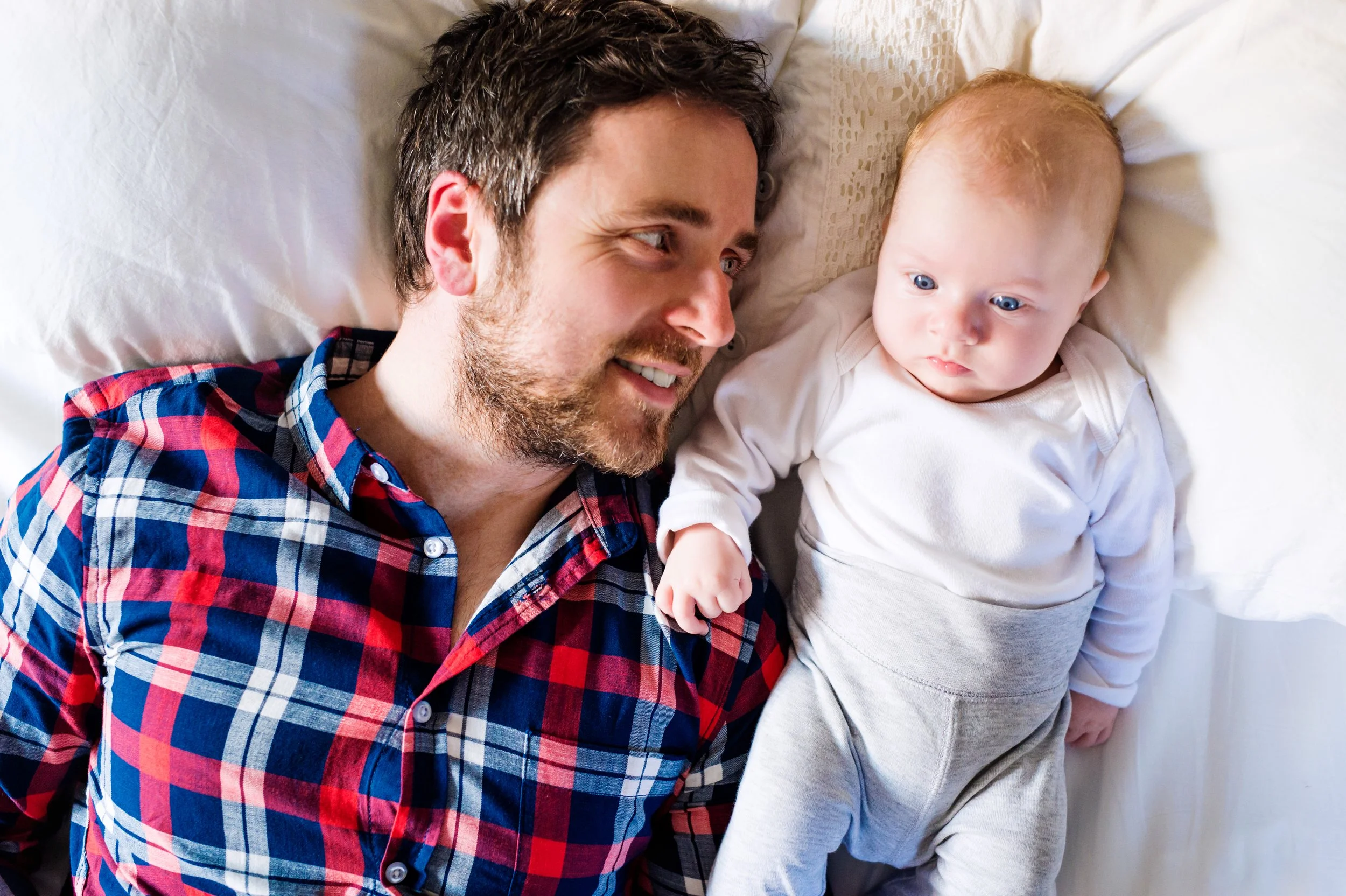 baby-boy-lying-on-bed-next-to-his-father-2024-10-20-13-20-31-utc.jpg