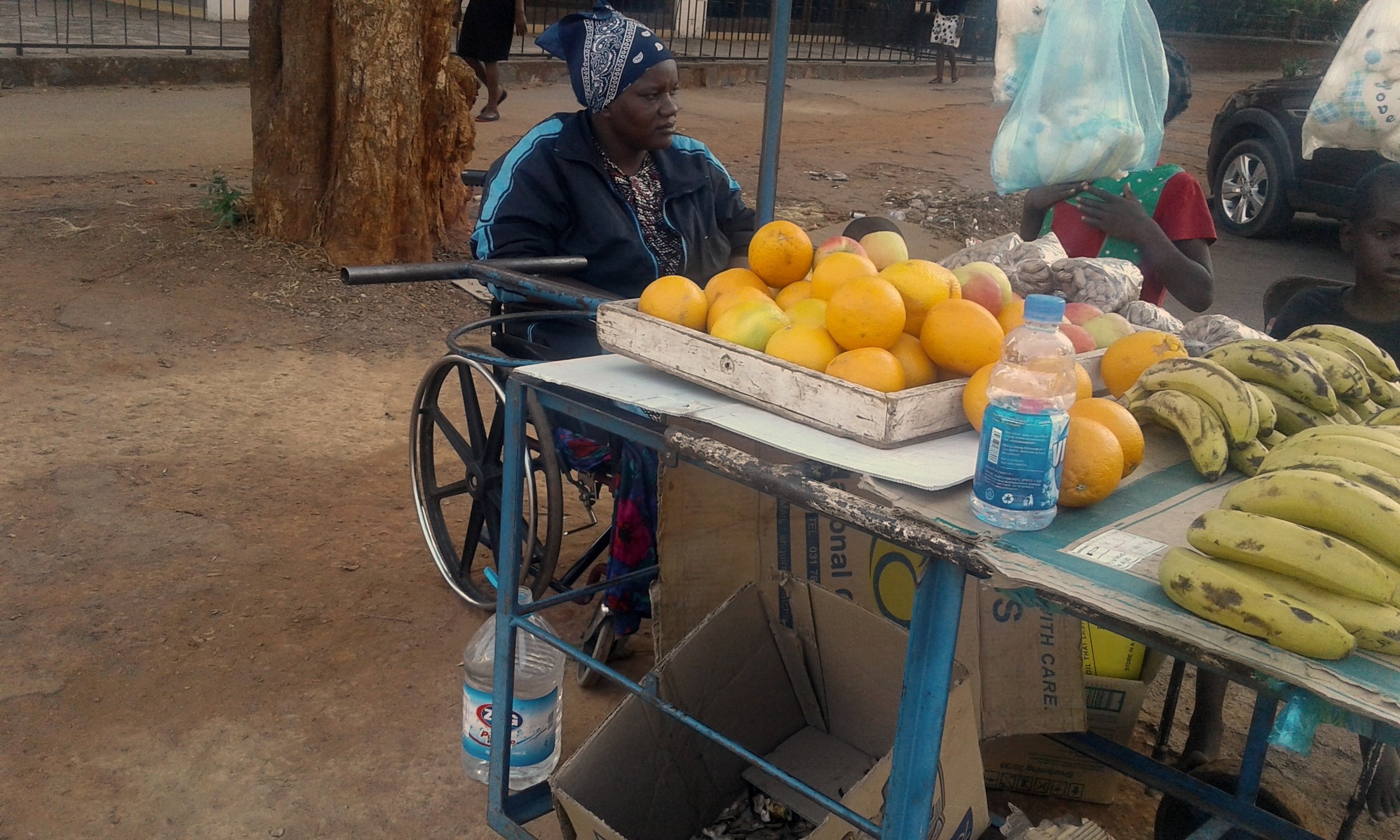 Disabled woman at her informal fruit and vegetable stall