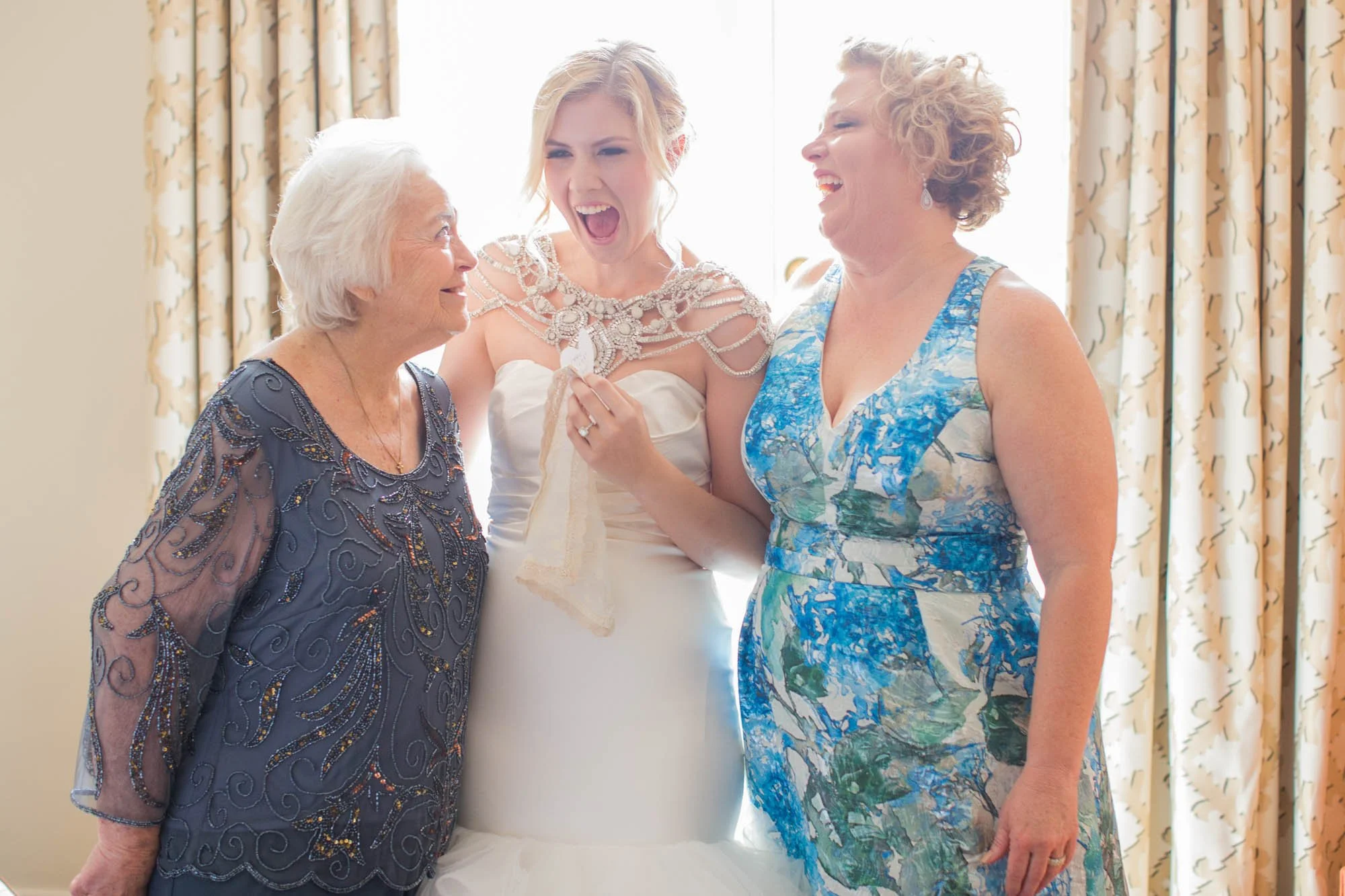 Three generations together, bride, mother of the bride and grandmother smiling and laughing at the Mansion on Turtle Creek wedding.