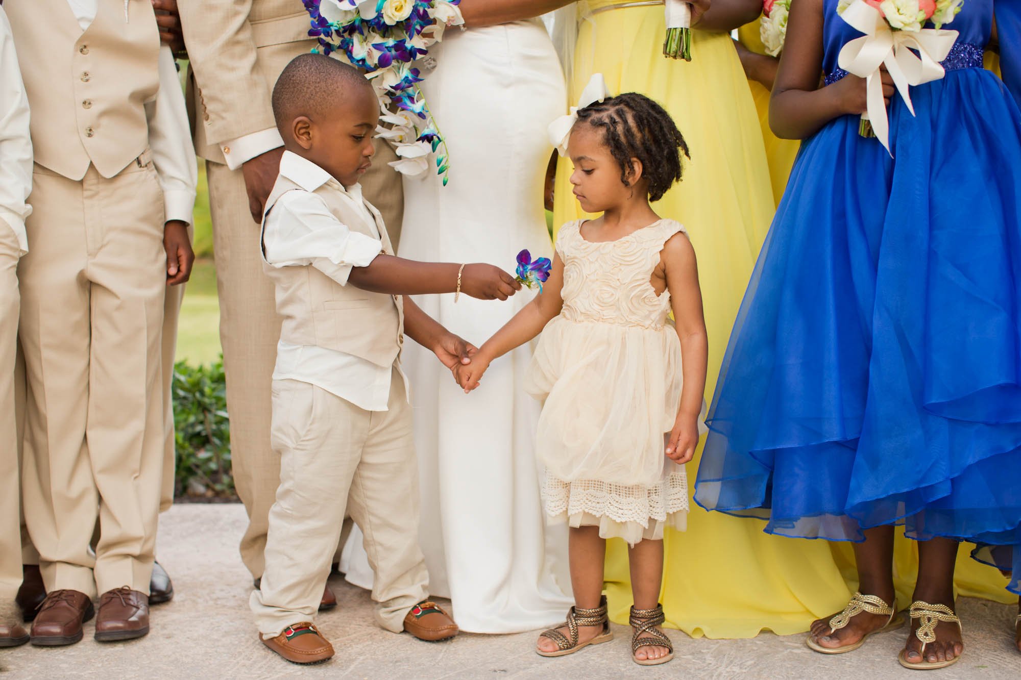Intimate family moment during Cliff Avril and Dantia’s Bahamas wedding, with children in the foreground and wedding party softly blurred behind.