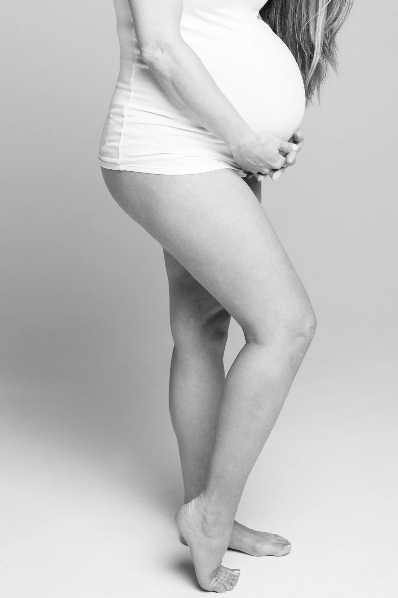 studio portrait of expecting mother belly detail black and white
