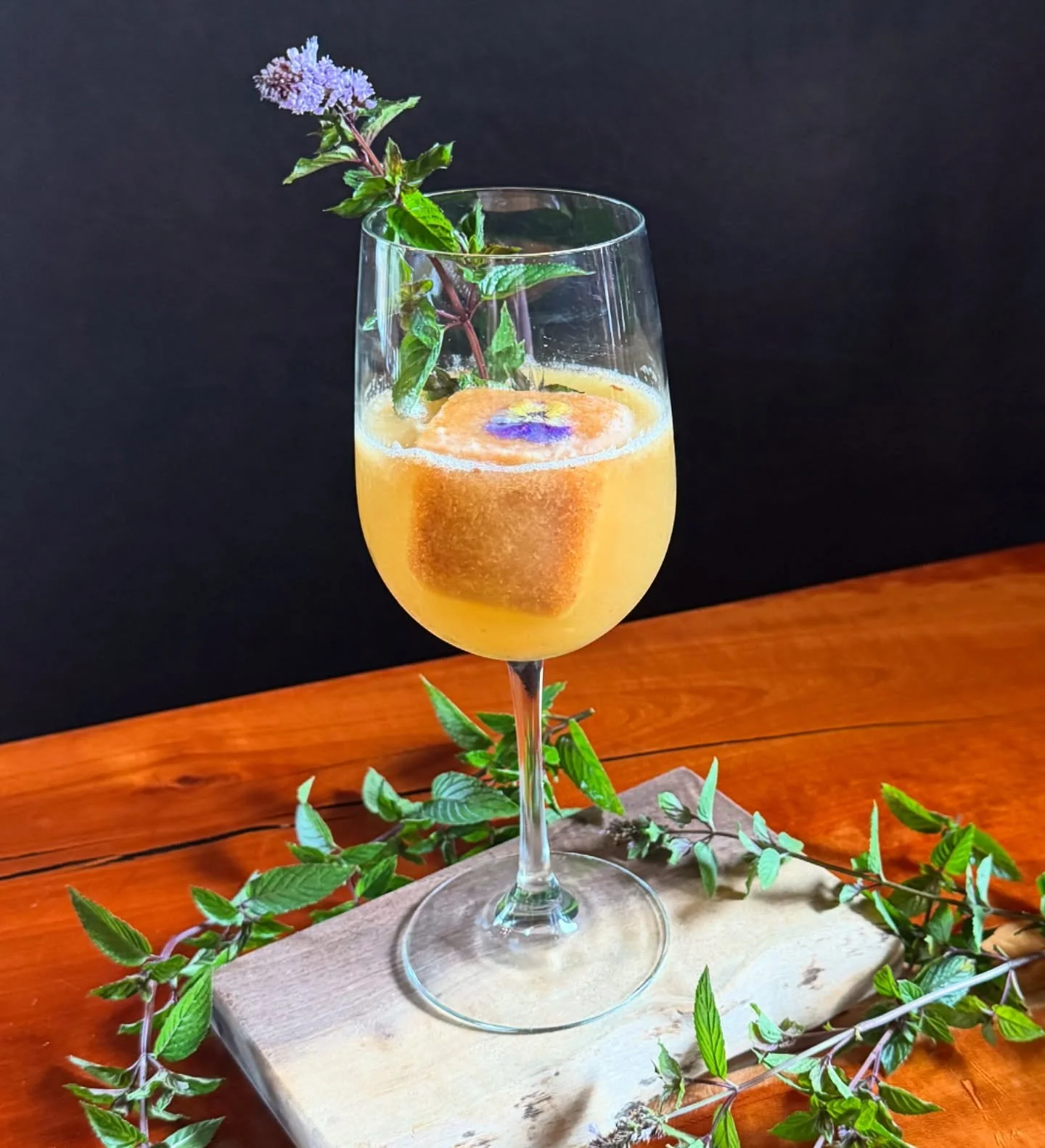 Patio weather &amp; Peach Bellini kind of weekend. Fresh juiced local organic peaches, prosecco, edible flower peach ice cube, chocolate mint. Supporting local farms @taproot_cider_house @taproot_farmstead @interwater_farms #ciderhouse @downtown_tc #