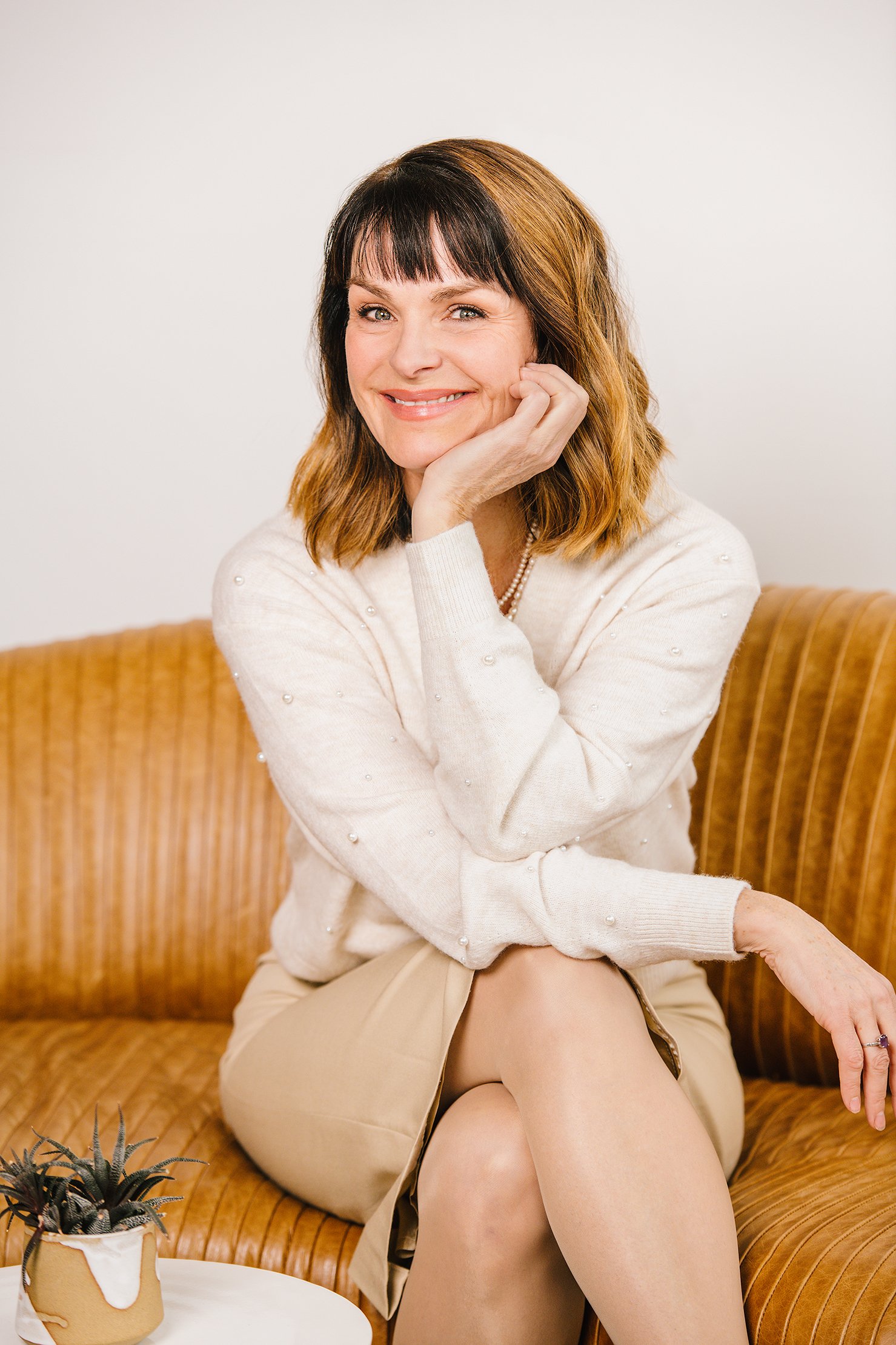 Beauty Portrait Woman seated on couch crossed arms studio headshots