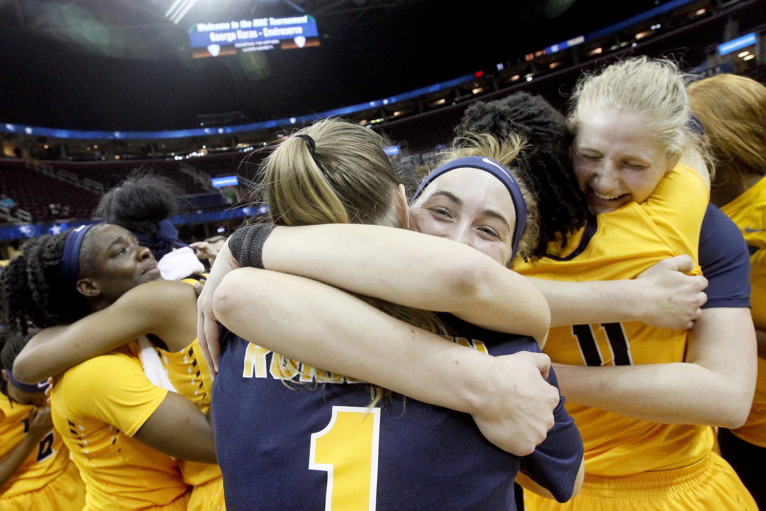  From left, Toledo's Janice Monakana is hugged by Kaayla McIntyre as Mariella Santucci, center, embraces by Sara Rokkanen (1) and Jay-Ann Bravo-Harriott (11) hugs Sophie Reecher, right, after the team beat Northern Illinois to clinch the MAC champion
