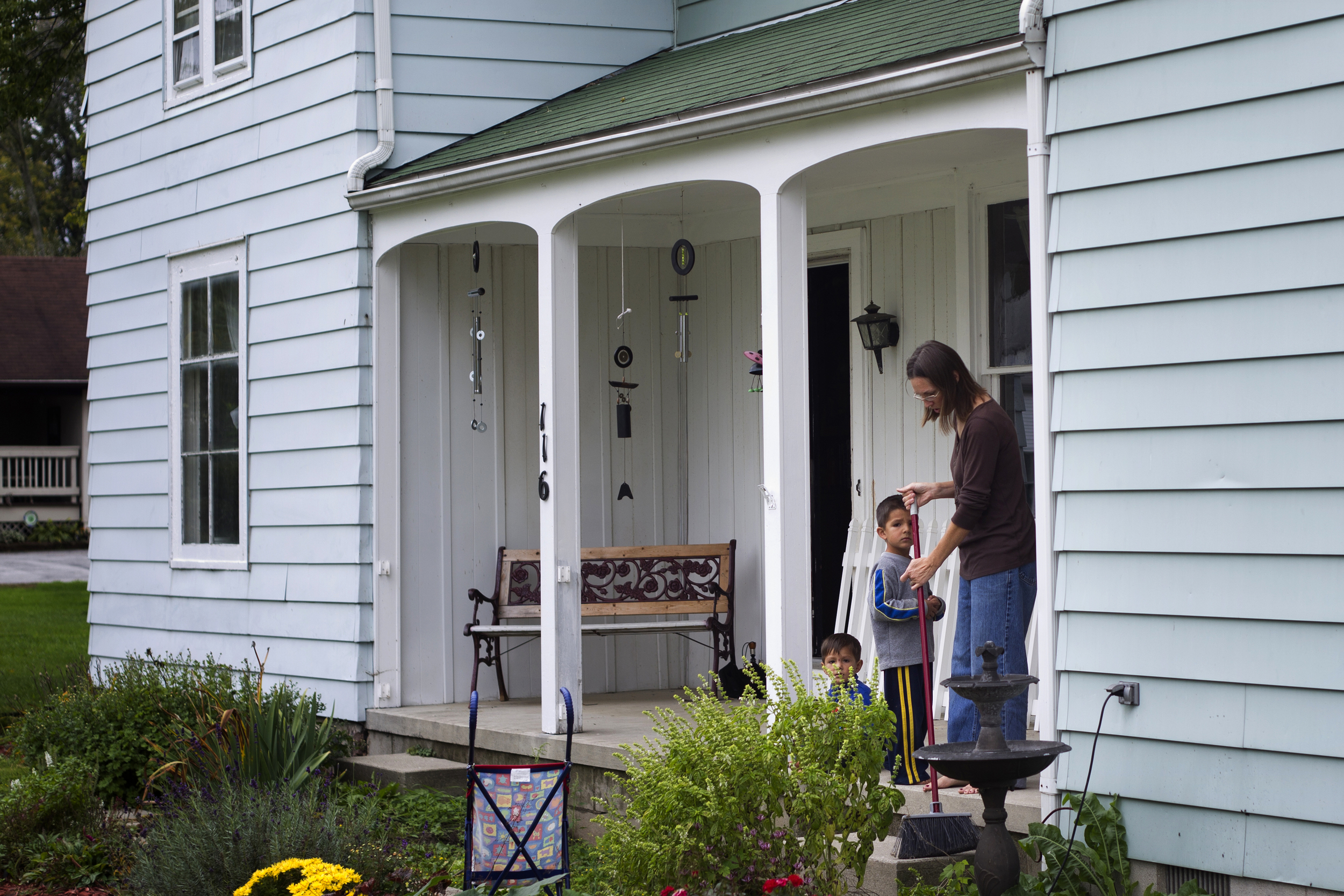  Rebecca Acosta, right, sweeps the front porch of her home in Pemberville, Ohio, as her children play in the yard. Though she said that she benefits from from some of the policies aimed at helping the poor, she was strongly against increasing taxes o