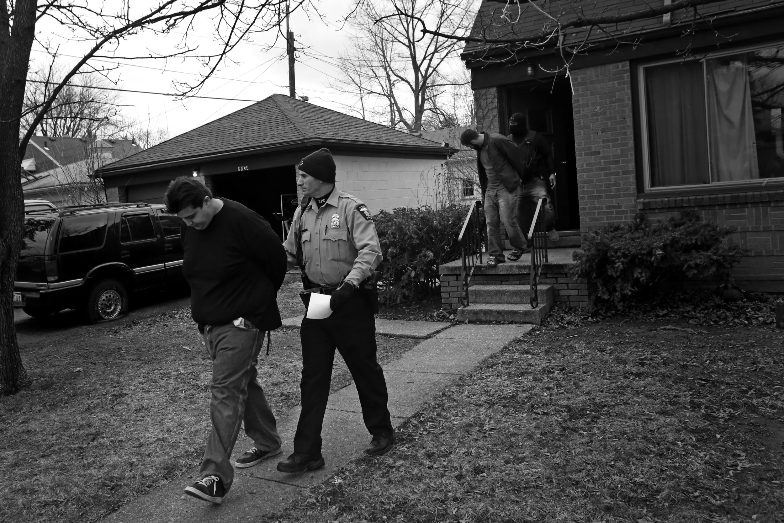  Adam Michilak, left, and Joshua Bennett, right, are led out a South Toledo home by police after Toledo Narcotics and SWAT officers raided the house at 3034 S. Byrne Road on April, 12. Police valued the confiscated materials, including up to 65 hydro