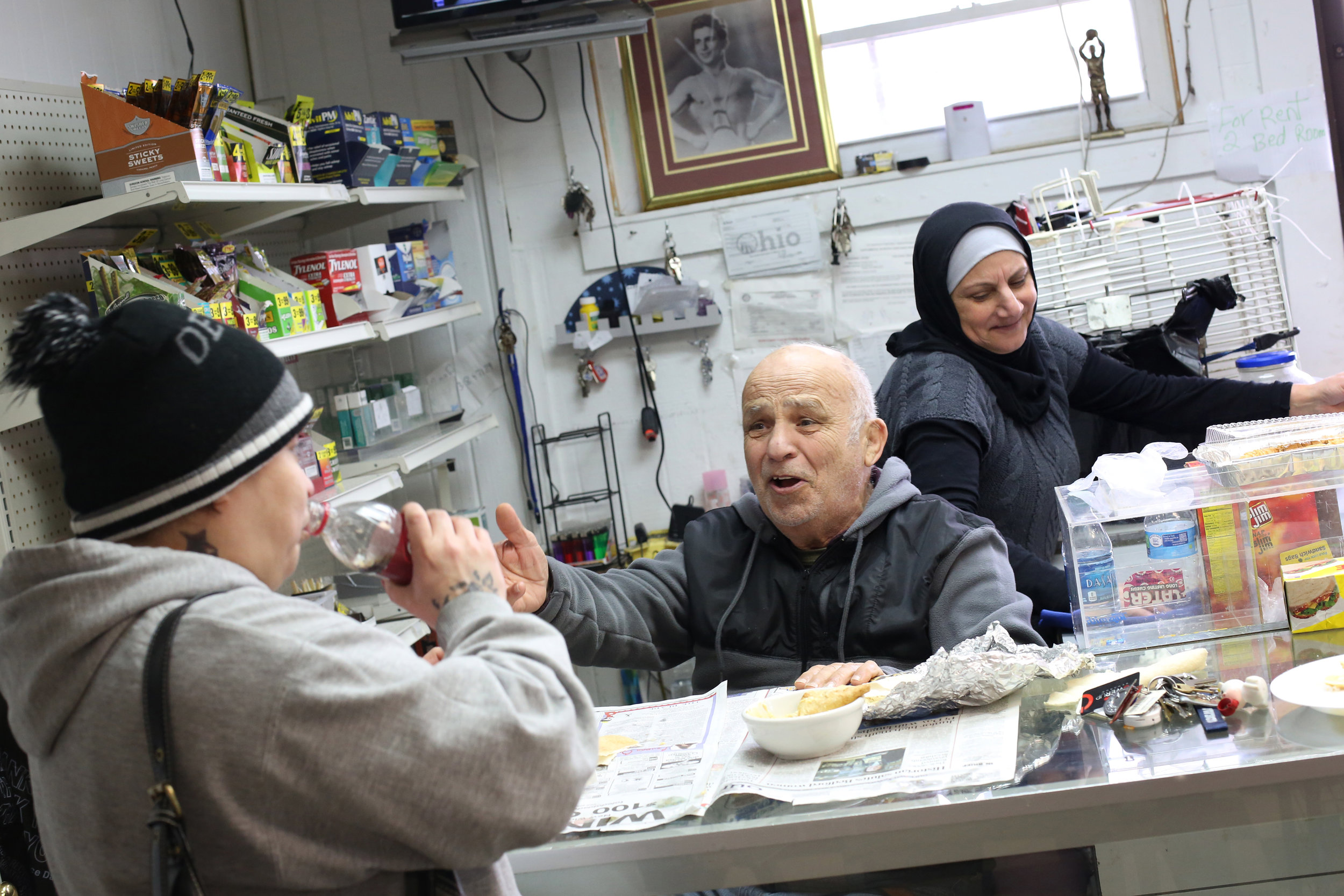  Customer Teresa Flores, a lifelong resident of the North End, left, laughs as she jokes with Hassan Cheaib, 81, as they share the lunch his wife Khadije brought to the Cheaib's carry-out store. Ms. Flores said she often goes out of her way to stop b