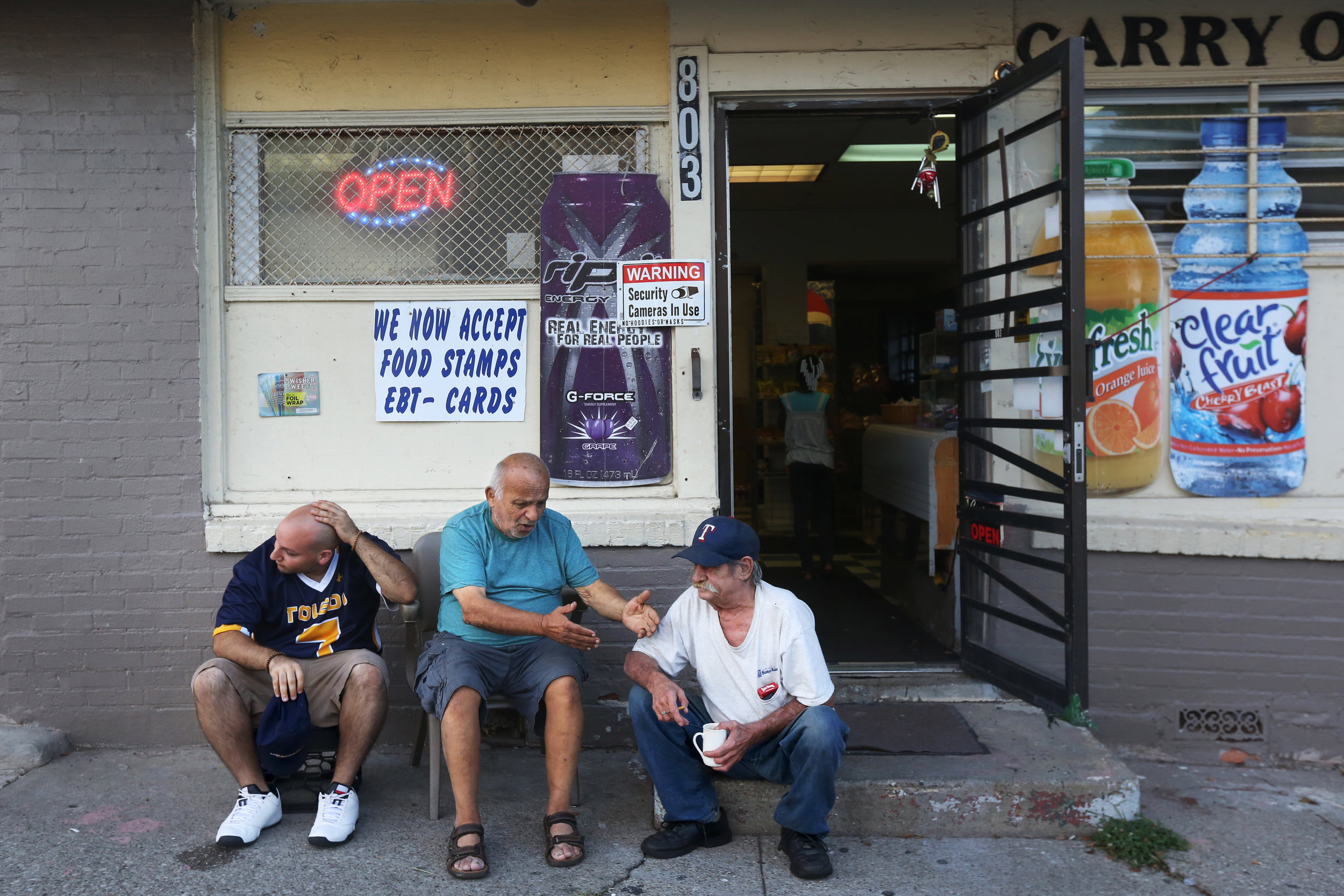  Radi Cheaib, left, listens as his father Hassan, 81, center, talks with their neighbor Kenneth Berry, right, about the perils of smoking outside Bush Carry Out in Toledo's North End. Hassan owns the carry-out, where he often spends time talking with