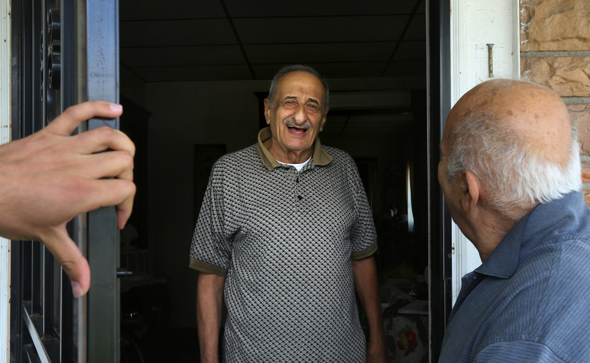  Toufic Awada, 81, center, greets his cousin Hassan Cheaib, right, at his home in Toledo's North End. Mr. Awada said he left Lebanon because of its conflicts. He now lives next door to Mr. Cheaib, with both families counting themselves as two of the 