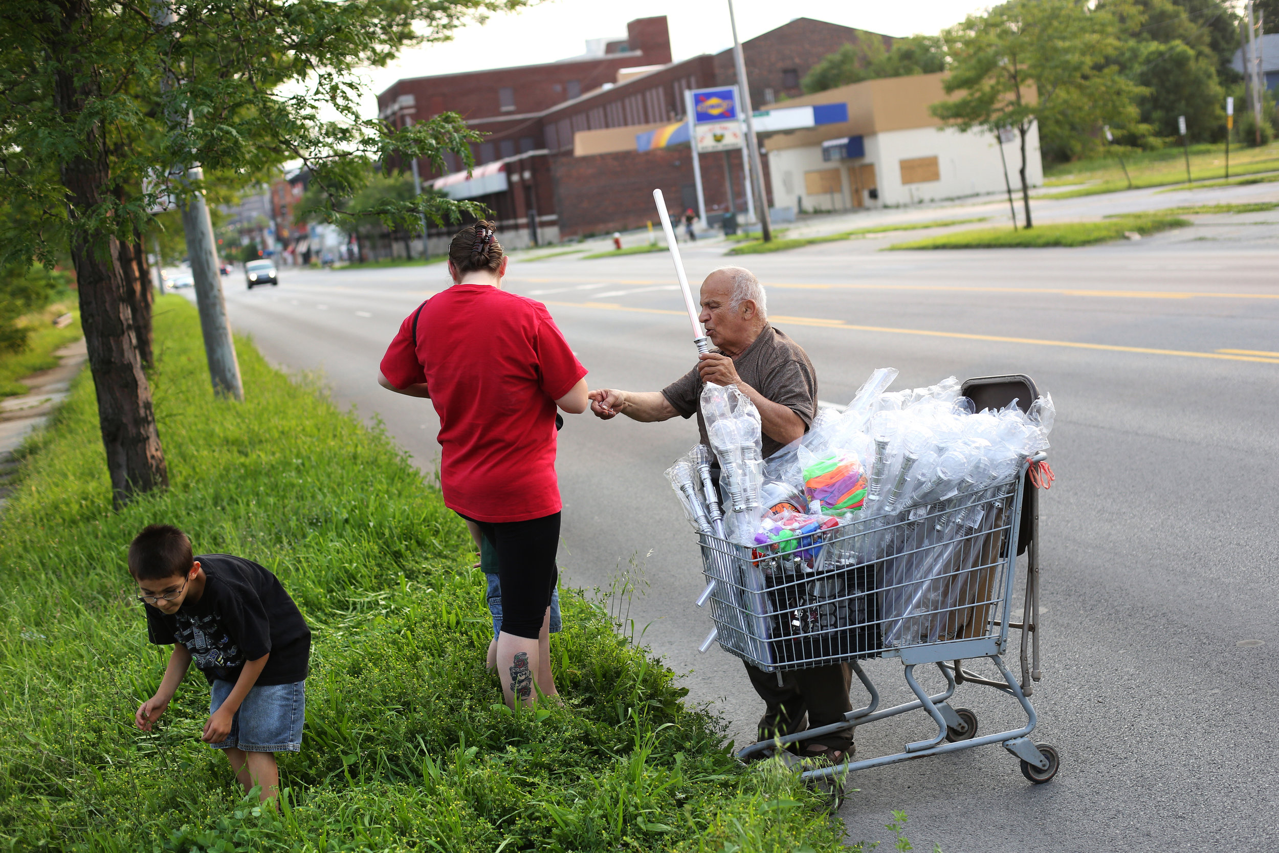  Hassan Cheaib, 81, right, sells glow sticks along Summit Street as he makes his way toward The Blade's 2015 Red, White, KABOOM Independence Day event at International Park in East Toledo on Saturday, July 4, 2015. As a child, Mr. Cheaib worked as a 