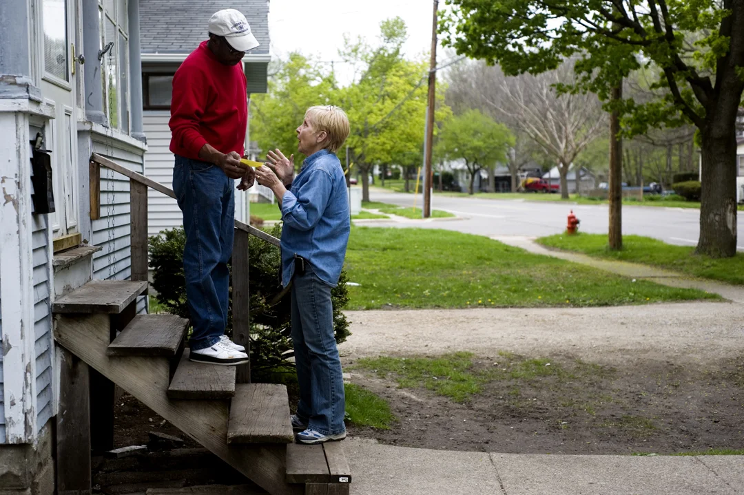  Pat Cripes, right, speaks with a neighbor of one of the tax foreclosed properties she is assessing. Pat and her husband fix up tax foreclosed properties after the county has taken possession in preparation for their auction. The neighbor expressed i