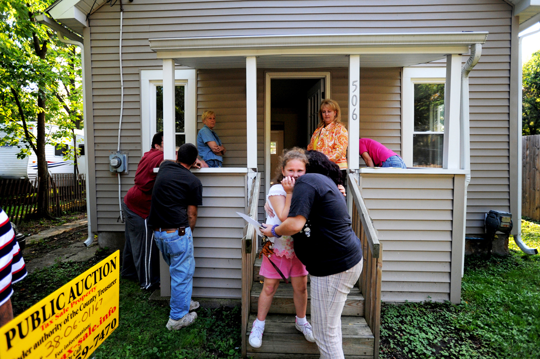  Jordan Cannon, 7, center, hugged her cousin's girlfriend, Misty Johnson, as the two stood on the steps of a home during a tax foreclosure open house in Jackson. Cannon's father, Rev. Gordon Cannon, far left, said he was looking into buying the home 