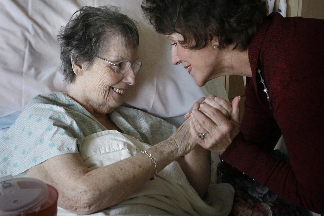   "Each room you go into you enter into another story," Joyce Rimmelin, right, said. Rimmelin embraced Claire Campbell, 82, on her volunteer rounds at ProMedica's Ebeid Hospice Residence in Sylvania. Rimmelin has been a believer in hospice care for m