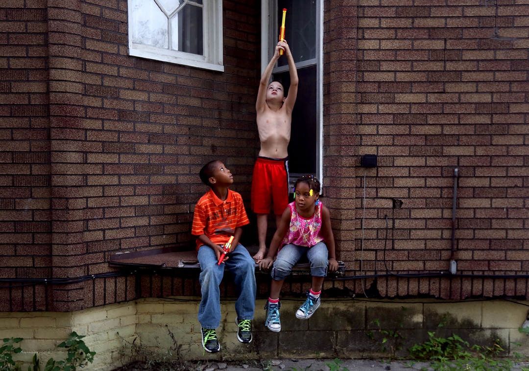  Devin Whaley, 10, left, D.J. Ferrell, 9, center, and Zyaire Whaley, 6, play together on their block in South Toledo. The kids had forwent their squirt guns even though the City of Toledo had declared the tap water safe to drink earlier Monday, Augus