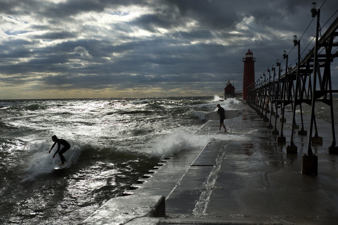  Surfers take advantage of high waves generated by a storm over Lake Michigan to hit the waves at Grand Haven State Park. Surfers who brave the great lakes often take to the water when the waves are higher during the winter months.  