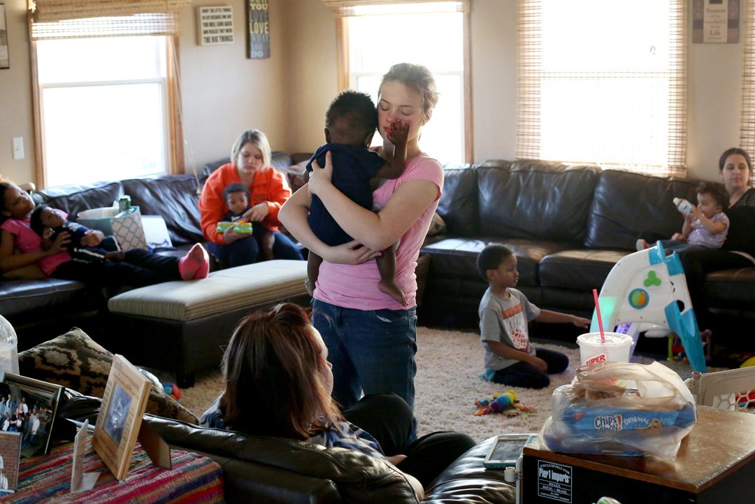  Raelyn Fenton Gogol, 12, holds her soon-to-be uncle Isaac, 1, who is blind, as he feels her face while their extended family visits together during a weekly dinner at the home of Kriste and Jeff Little in Walbridge. The Little's have been foster par