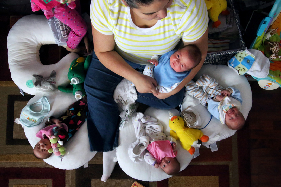  Laura Baldwin holds her son Logan as she takes turns feeing the rest of her quadruplets at the home she shares with her husband, Bill, and their three-year-old daughter, Leah, in Swanton. The babies, from left, Reghan, Madalyn and Ryan, are fraterna