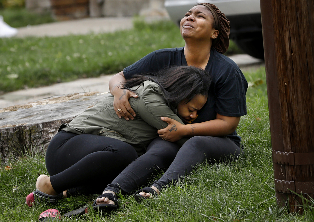  "That's my baby," a woman sobs, left, as another woman cries out, "That's my brother," while holding one another in the front yard as Toledo police investigate a shooting Tuesday, October 10, 2017, at 729 Brighton Ave. in South Toledo. Toledo police