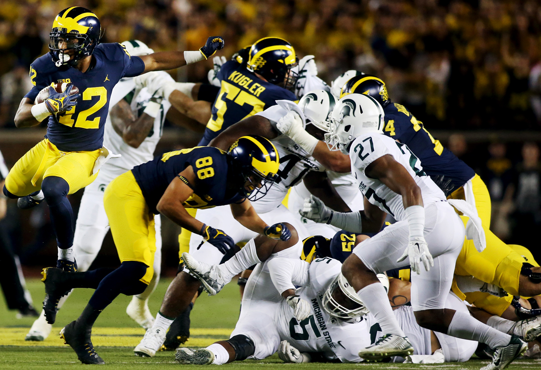  Michigan's Chris Evans (12) leaps over the Michigan State defense on the run in the first half of the Saturday, October 7, 2017, football match up at the Big House in Ann Arbor. Michigan State won, 14-10.












































