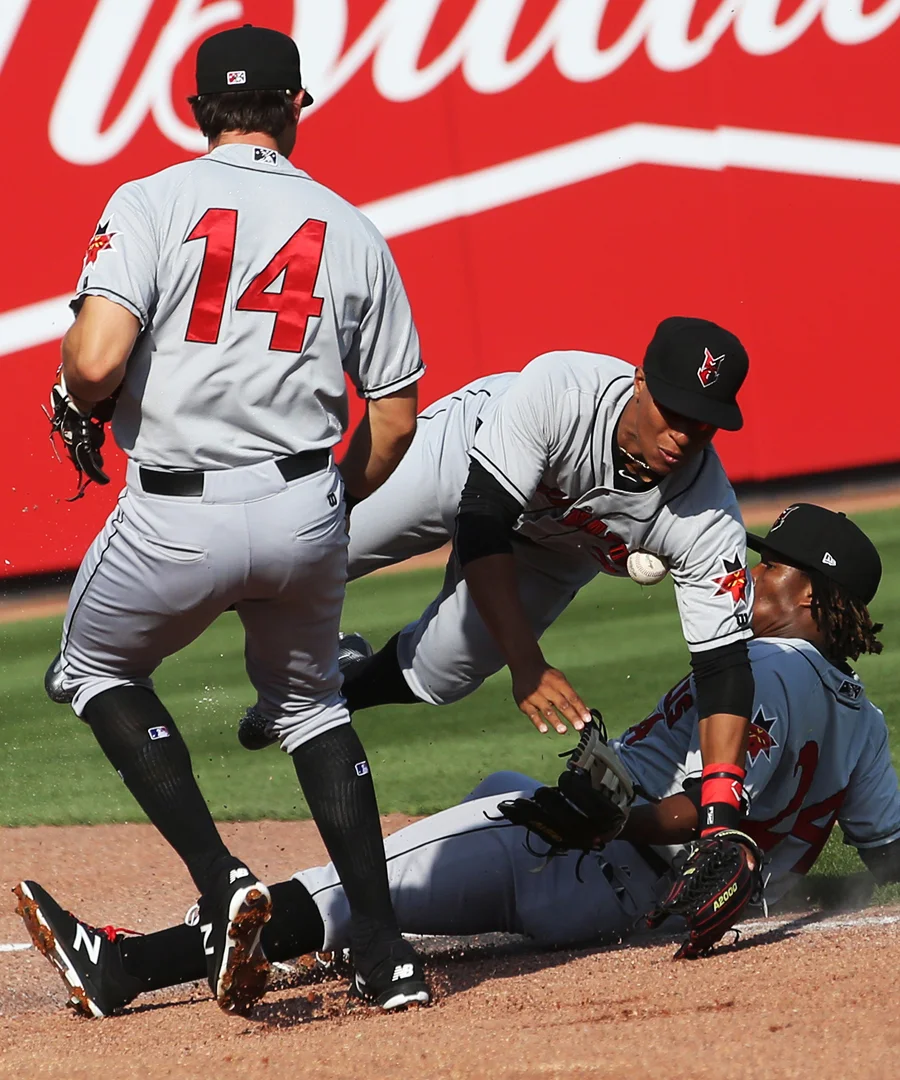  Indianapolis' Eric Wood (14) Christopher Bostick, center and Gift Ngoepe, right, can't make the catch off a Mud Hens hit in the bottom of the first inning during the Saturday, April 15, 2017, baseball match up at Fifth Third Field in downtown Toledo