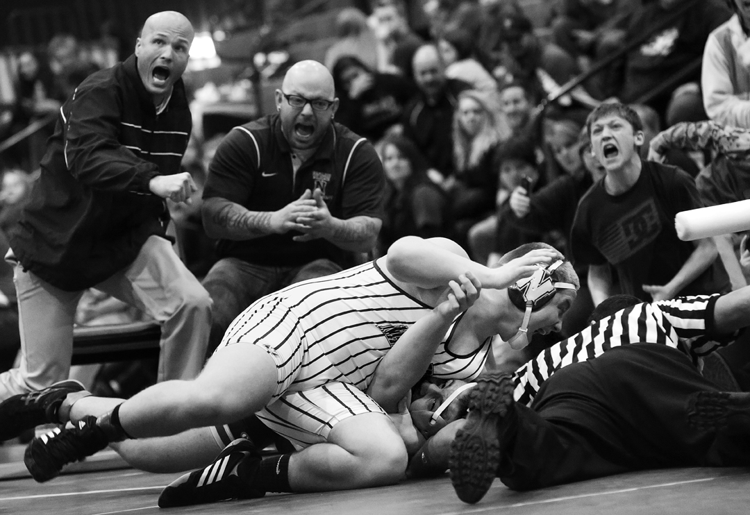  Napoleon's Andrew Pettit, center, his coaches and supporters cheer together as Pettit pins Maumee's Brandon Phillips during the 220 pound weight class match at the Saturday, February 7, 2015, Northern Lakes League Championship meet at Springfield hi