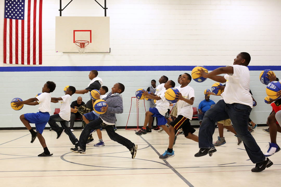  Erian Gambriell, 12, left, leads the pack as he and other children run through basketball drills together during the 2015 Dribbling with Dads Initiative Saturday, June 20, 2015, at the Frederick Douglass Community Center in West Toledo. About 125 ch
