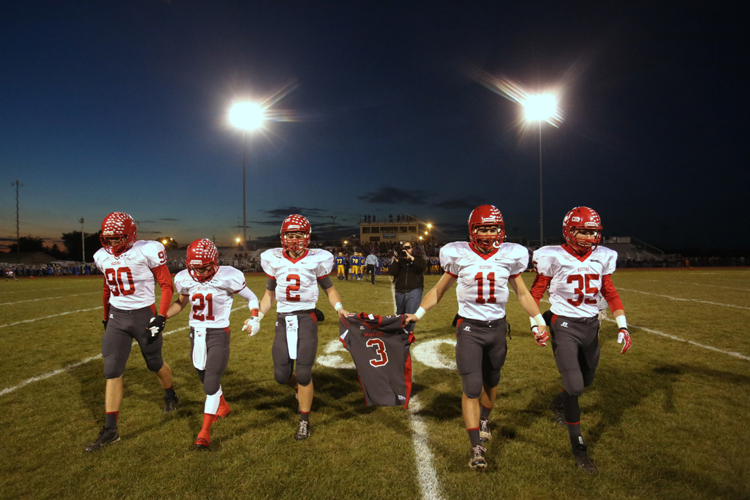  Bedford's senior Jeremy Harris (90) Lucas Mayo (21) Boss Brad (2) Alec Hullibarger (11) and Jack Maison (35) carry their teammate Colton Durbin's number 3 jersey off the field before the start of the Friday, Oct. 25, 2013, match up between Monroe Je