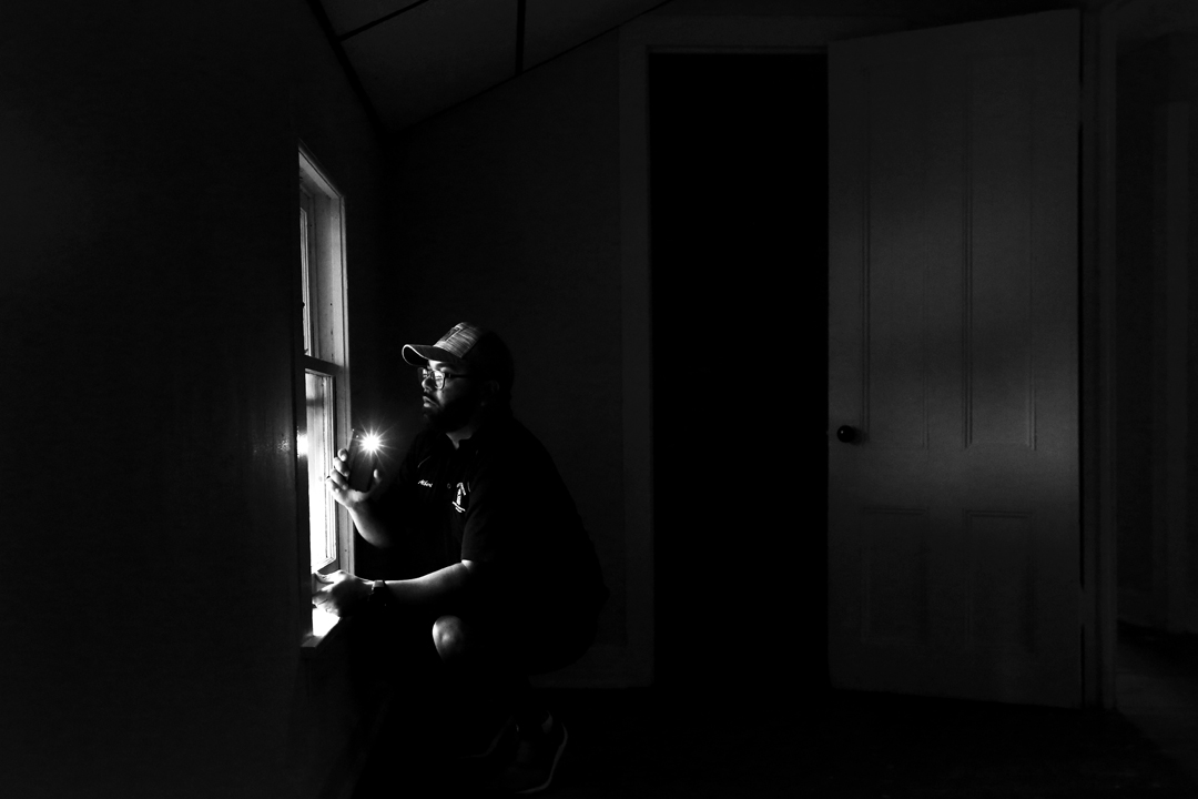  Albert Algerian, a Rochester Code Enforcement Officer, uses his phone light to check for flaking paint on a window during an inspection  at a rental home in Rochester, N.Y., on June 22, 2017. A new Toledo law, based on Rochester's decade-old lead la