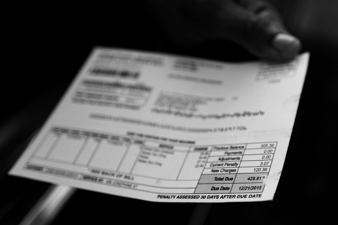  Flint resident Audrea Crawford holds out her city water bill after stopping at a distribution site to pick up a case of bottled water Wednesday, January 20, 2016, in Flint, Mich. Crawford says her bill of $428.81, which was due on December 21, 2015,