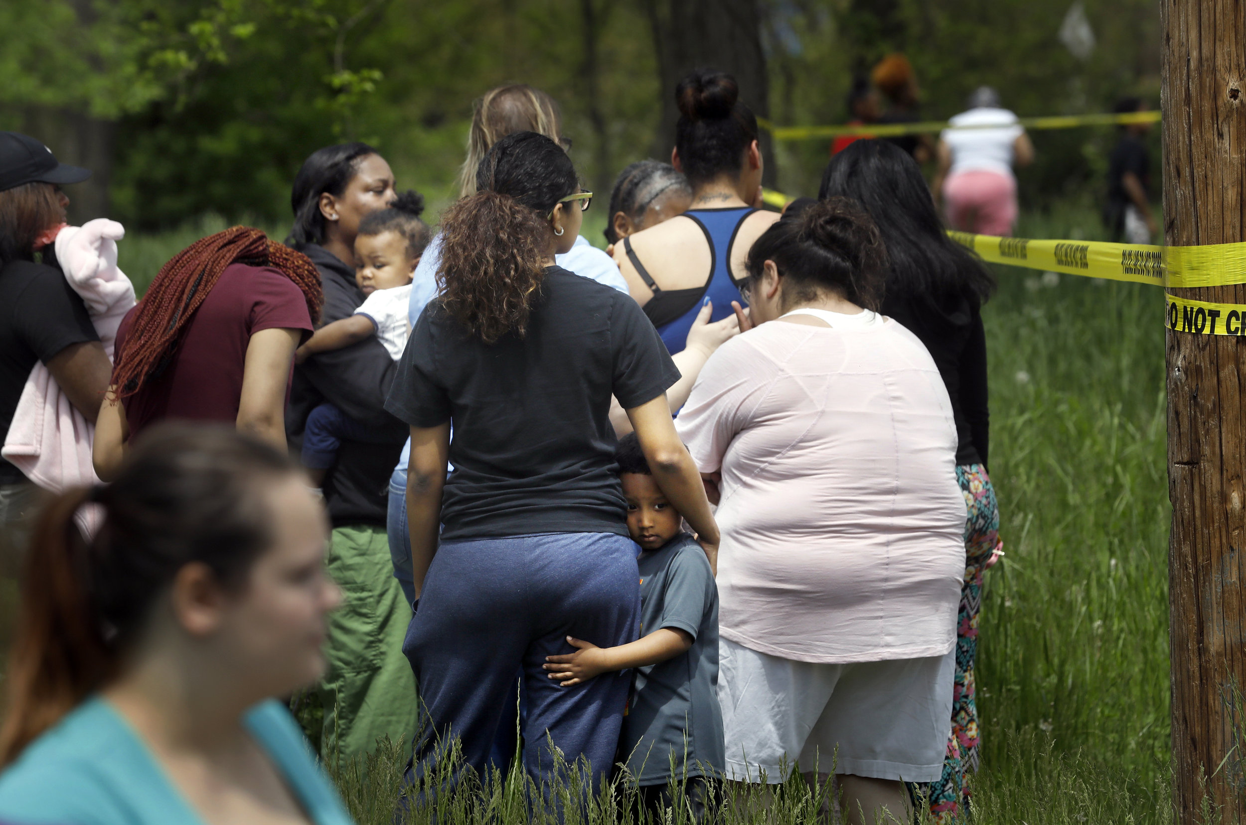  Torice Jackson, 3, clings to his mother Brooklyn Ruiz, as she talks with other mourners while Toledo Police investigate a shooting death that occurred in the early afternoon of May 17, 2018, on Highland Avenue near North Detroit Avenue in Toledo. Po