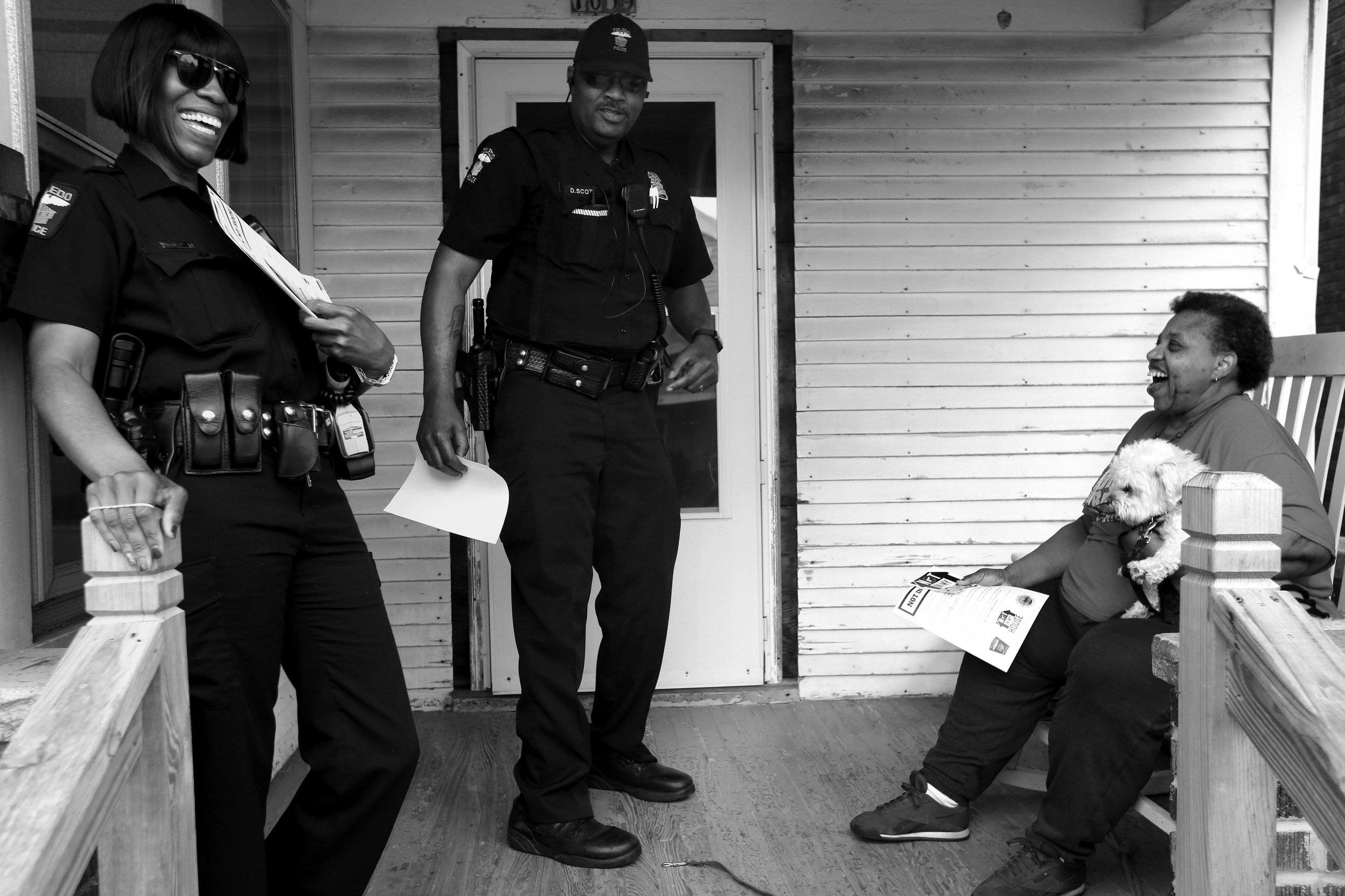  Toledo police Officers Melissa Stephens, left, and Donald Scott, center, joke with Constance Howell as the officers go door-to-door promoting a new program called, "Not in My House" on May 10, 2018. The new initiative allows Toledo residents to call