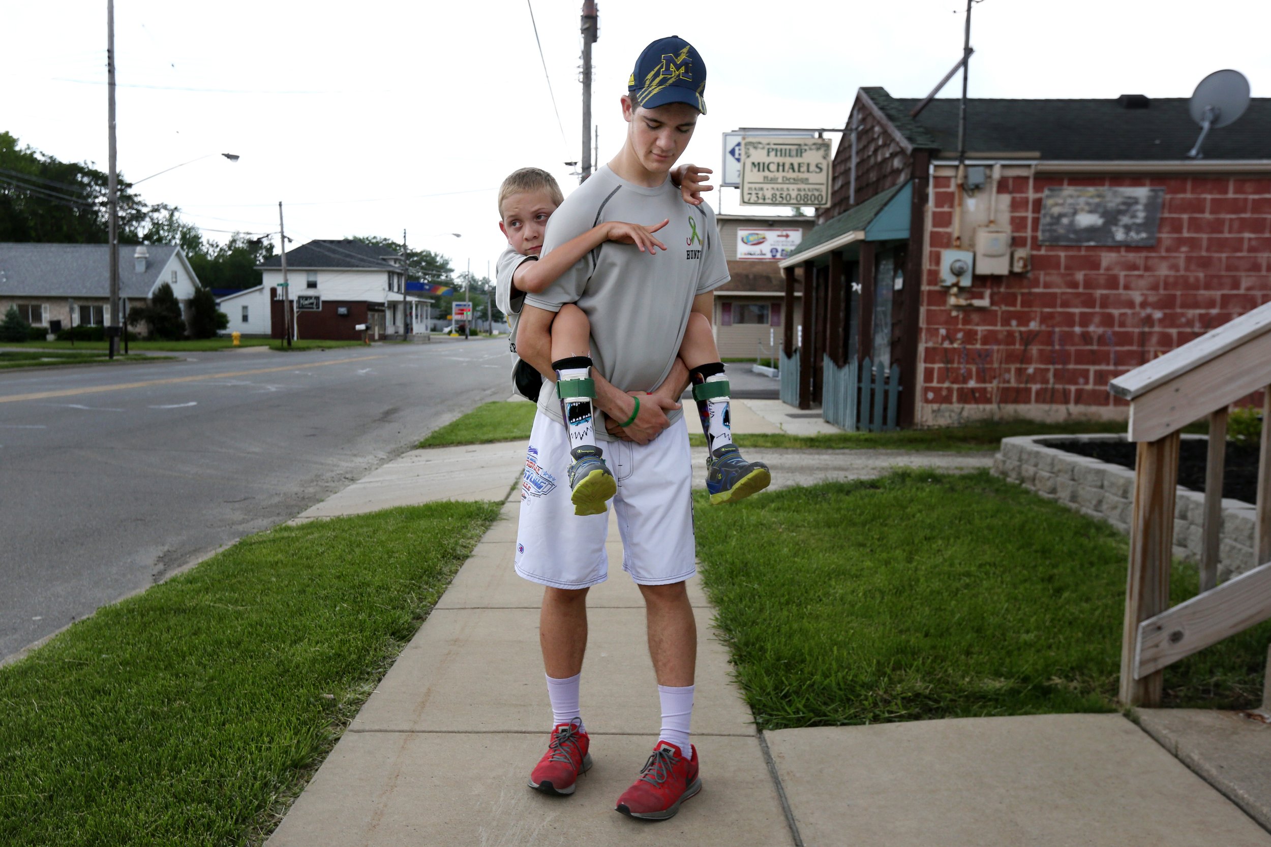  Hunter Gandee, 15, carries his brother Braden, 8, on his back for long walks to raise awareness of Cerebral Palsy, which Braden has, and promote, "a truly accessibly world." The brothers were walking through Temperance, Mich., on May 30, 2015, to di