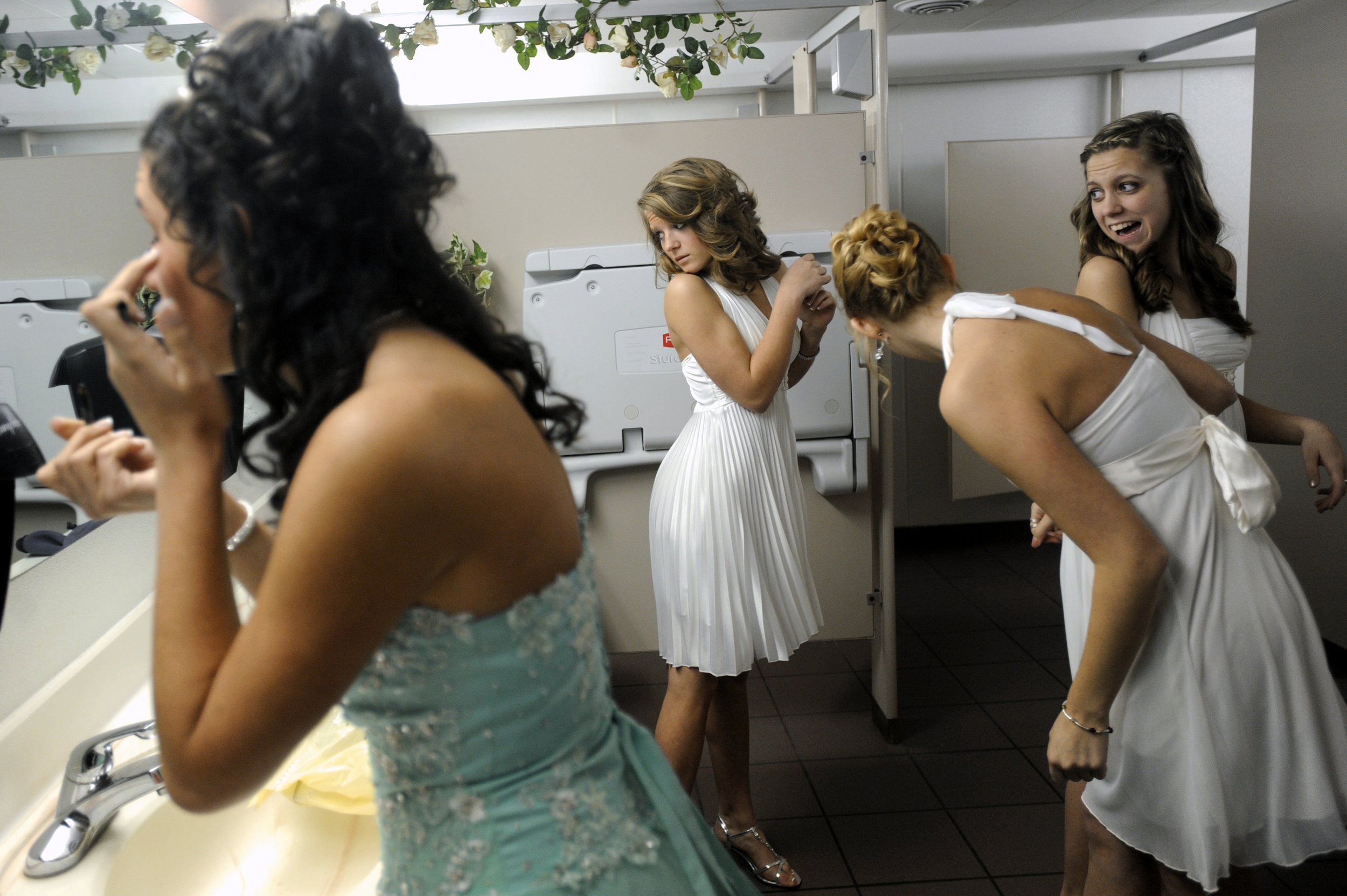  While quinceañera Clara Male, 14, left, finishes her makeup, Logan Raczkowski, 14, center, and other members of Male’s court do a last minute check of their dresses before the start of the ceremony in Jackson on March 5, 2010.  