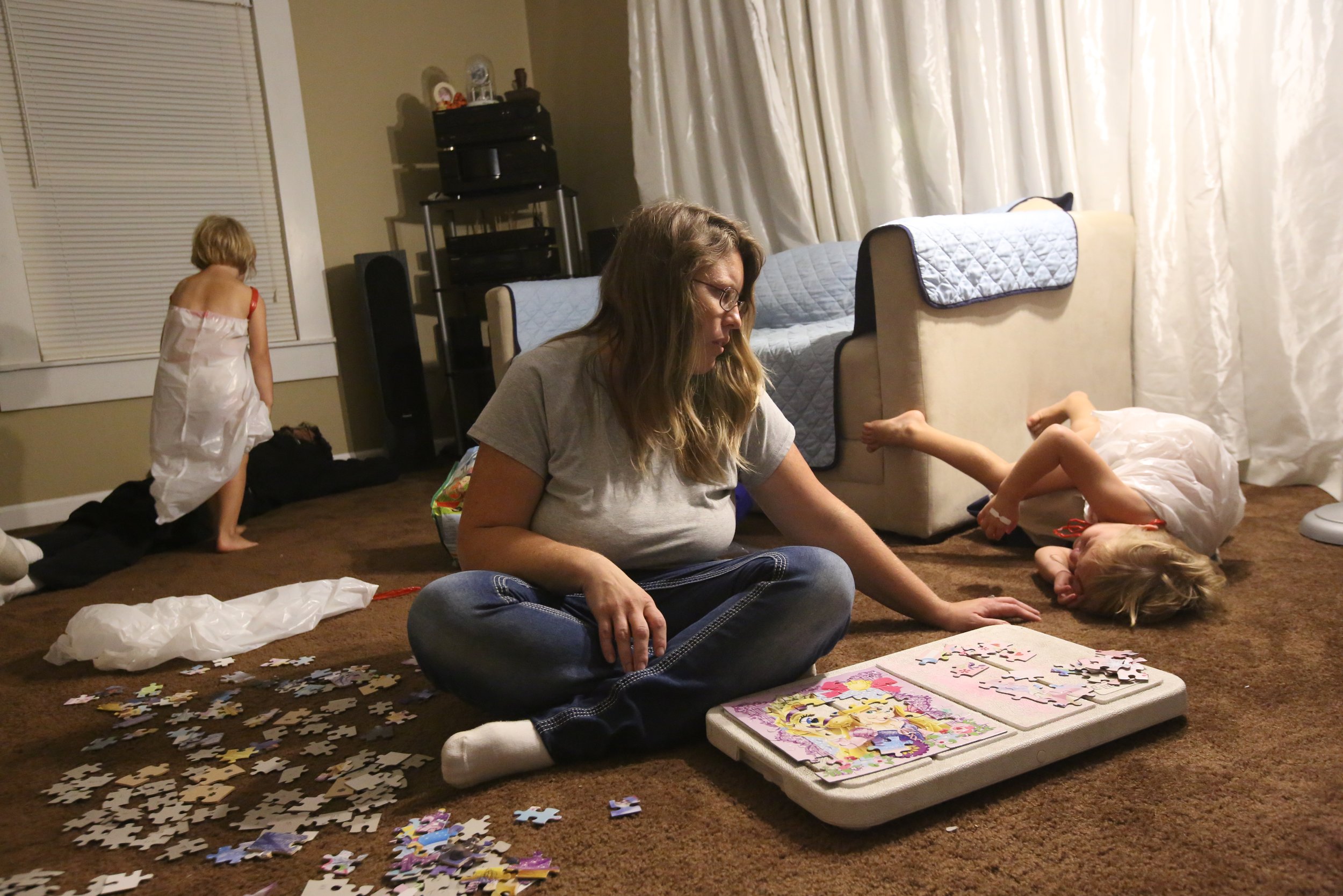  Josianne Thomas, center, tries to help her daughter Hailey, 4, wind down for the night as Hailey’s twin sister Tiffany wakes their father, Mike, up to ask him to head for bed at their home on Sept. 29, 2016. The attack on their family has made sleep