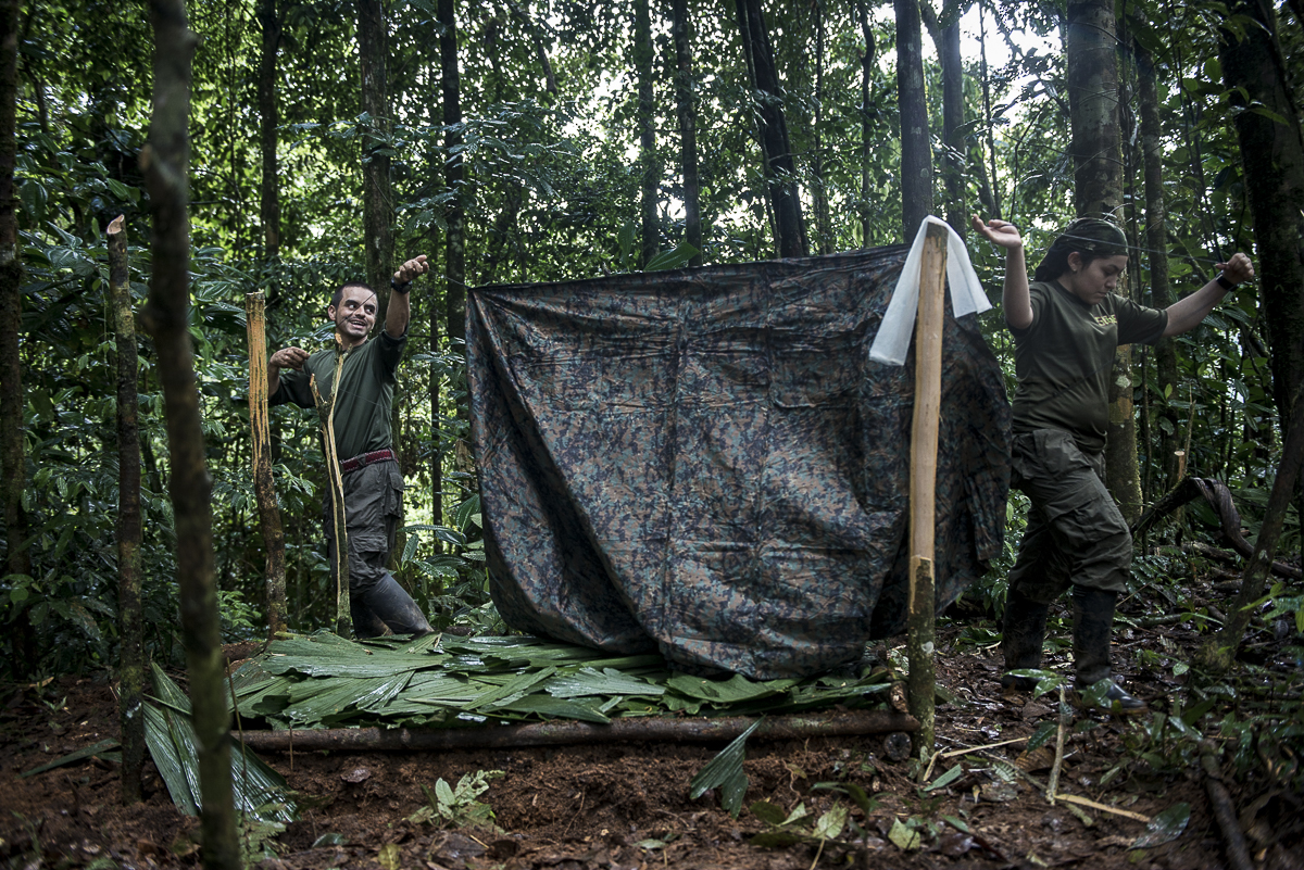The two guerrilleros are put up the “caleta”: In the camp, every guerrillero settles into their own place under a camouflage tarp that protects them from the rain. They name it their “home”. It prevents detection by the airplanes. In war times, their main fear was to be bombed by night. (October 14, 2015, North Caquetá)