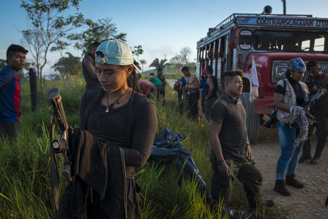 The caravan arrived near Campo Hermoso, where the guerrilleros takes another bus to travel on the paved road. A guerrillera is cleaning her weapon after the one-day trip on the chiva. (December 9, 2016, Caqueta)