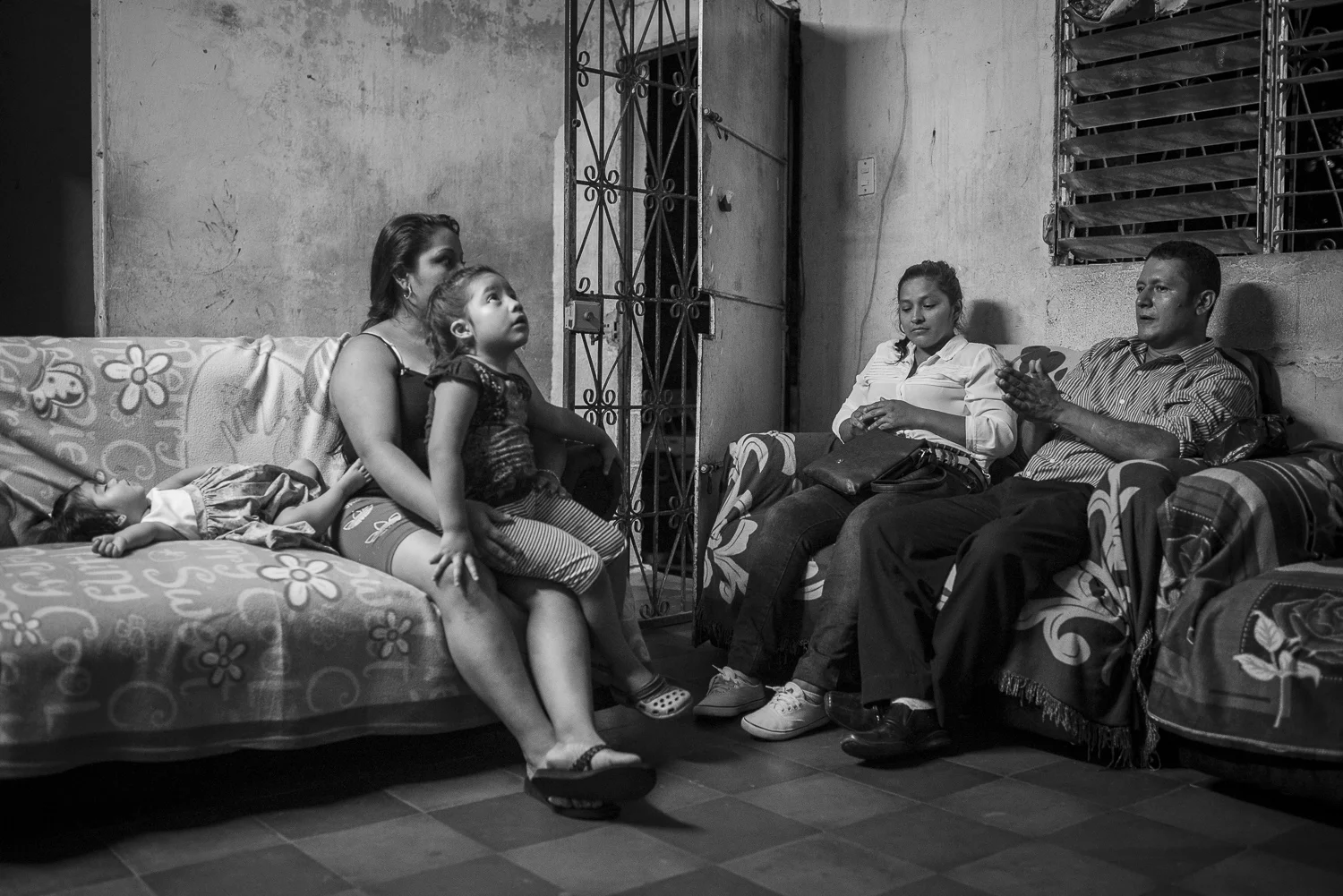 At home with her two young girls, Maira is listening to Angel sit near his girlfriend. Her husband is detained for his past activities as gang member. He is now an evangelical. Maira is part of New Creation church, Angel' ministry. (April 14, 2018) Credit: Nadège Mazars / Hans Lucas studio