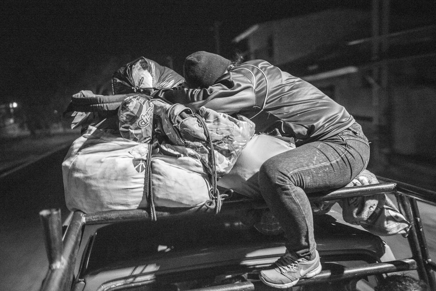 Maira is sleeping on the top of the pick-up during the trip to La Gotera jail. Angel organized a trip to San Francisco de la Gotera jail with twelve women, wife or mother of a detained, at 5 hours of San Salvador. The purpose is to bring some packages of food or first need products to the prisonners. Since almost two years the jail is under restrictive measures that prohibit any contact with outside. In late April, the measures started to be more flexible. (April 19, 2018) Credit: Nadège Mazars / Hans Lucas studio