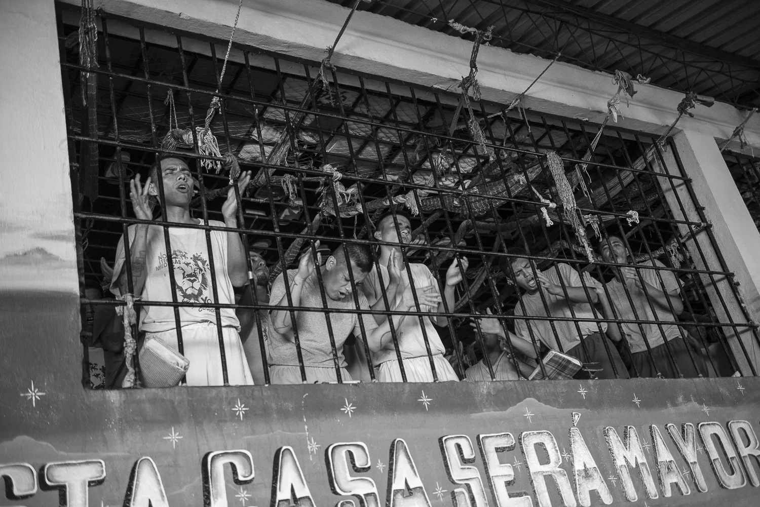 Prisonners at the 4,5,6 yards of La Gotera's jail pray at the worship of the Final Trumpet church. The Church was created in 2010 inside the jail. (San Francisco de Gotera, El Salvador, April 19, 2018) Credit: Nadège Mazars / Hans Lucas studio