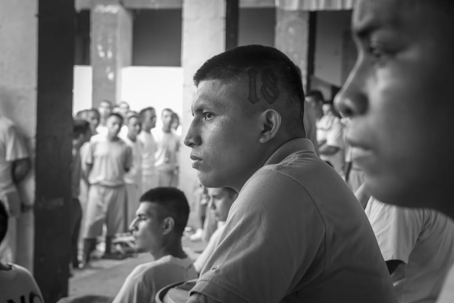 Inmates at the 1, 2, and 3 yards are participating to the workship of "Strong Tower" church in La Gotera jail. At the center, one of the inmates has a 18 tattooon the skull in reference to his former gang, Barrio 18. (San Francisco de Gotera, El Salvador, April 19, 2018) Credit: Nadège Mazars / Hans Lucas studio