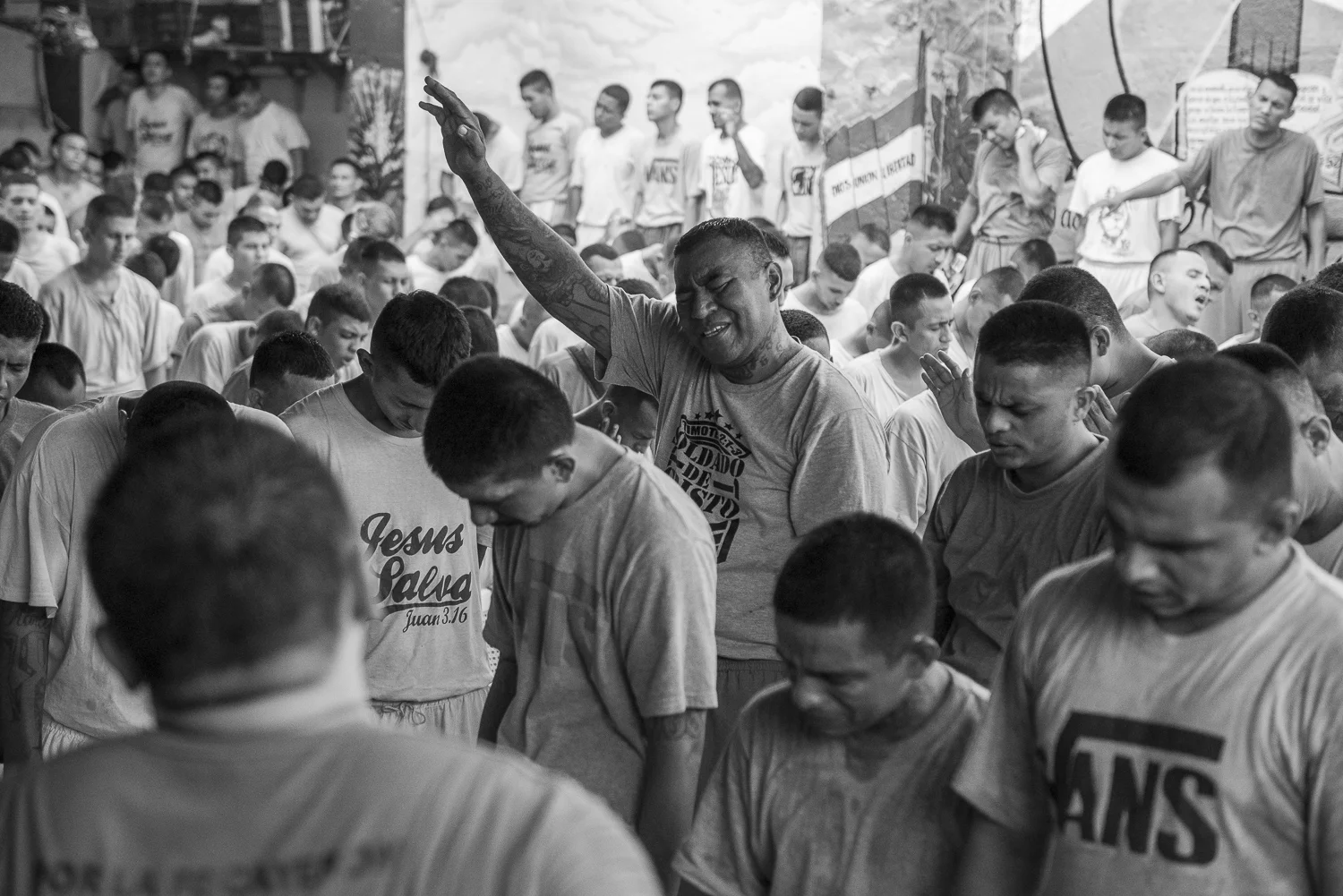 At the center, "Champo", a well-know leader of the 18-R gang in La Dina colony, participes with commitment to the worship of the Final Trumpet church. The director of the jail, Oscar David de Navides Bermudez, tells that 120 gang leaders were converted to Christianity in the last months. (San Francisco de Gotera, El Salvador, April 19, 2018) Credit: Nadège Mazars / Hans Lucas studio