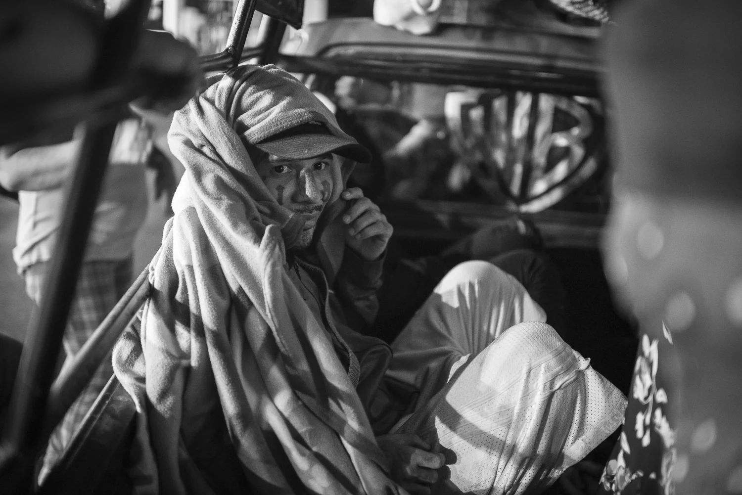 At a gas station, Carlos continue to hide himself. With his tattoo on his face, he could be in danger or put in danger everybody in the car if a member of an opposite gang is crossing the way of the pick-up. (El Salvador, April 19, 2018) Credit: Nadège Mazars / Hans Lucas studio