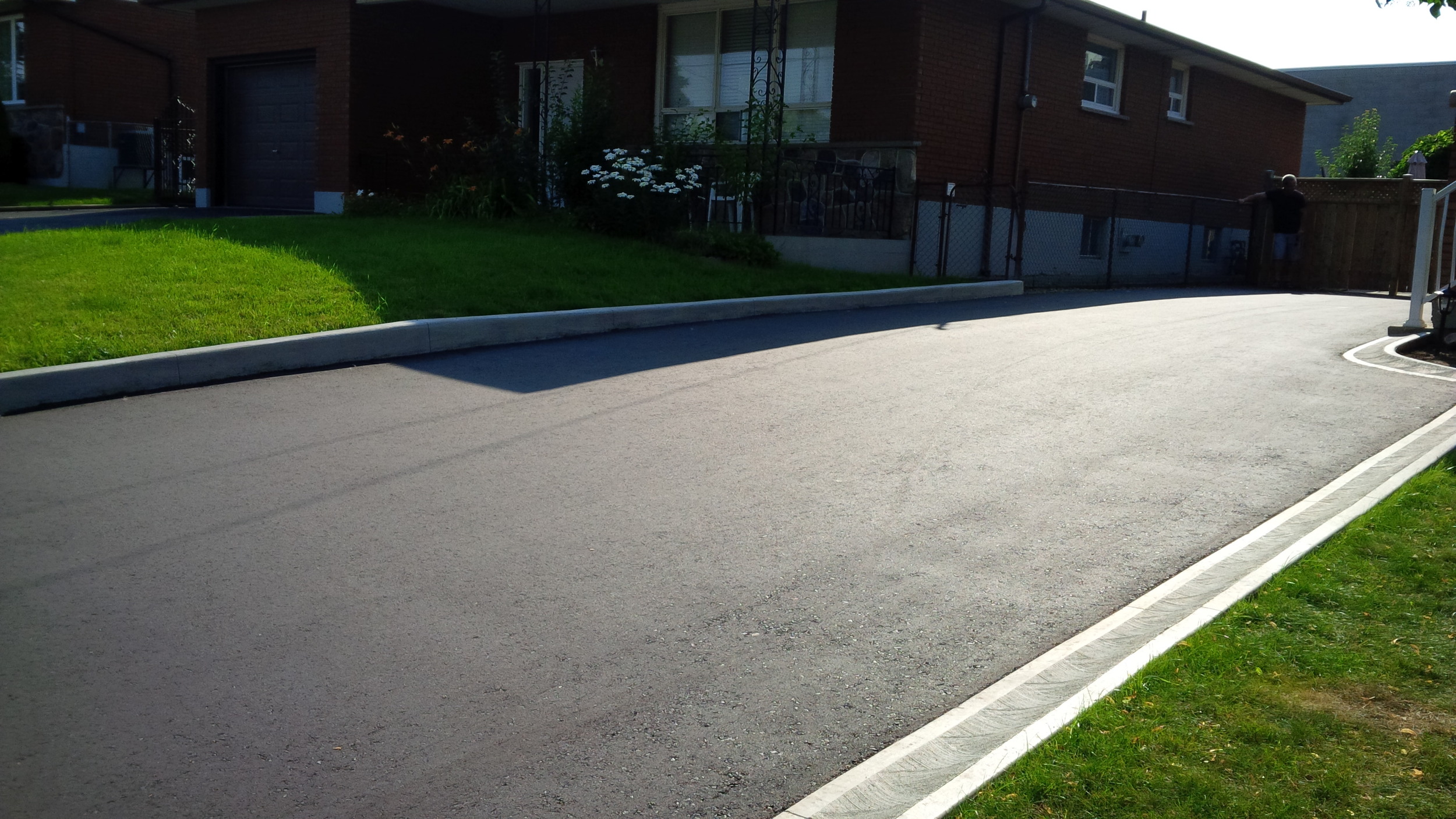 Asphalt drive way with concrete curbing.