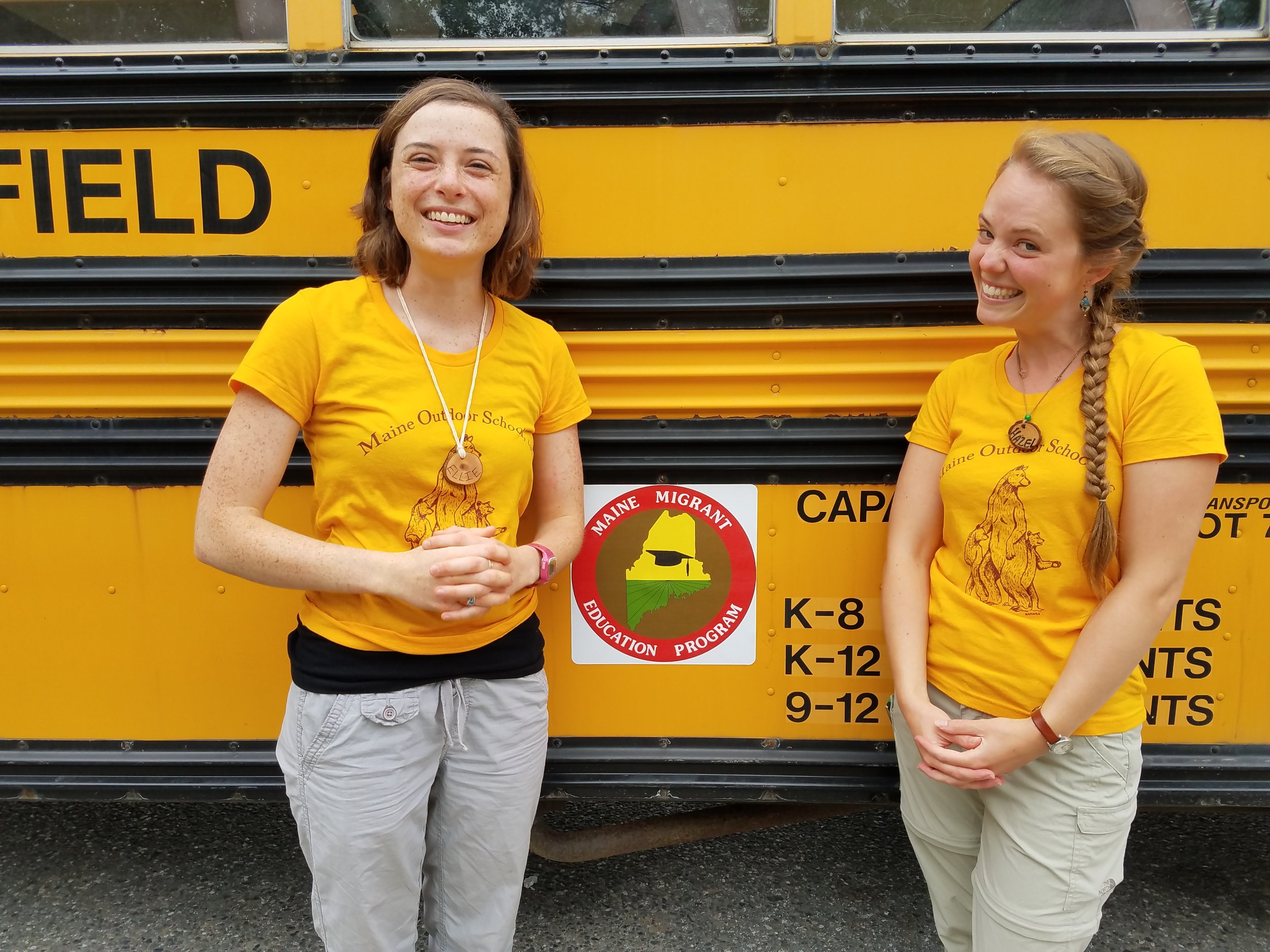 Ellie and Hazel waiting for students to arrive and enjoying how their MOS t-shirts match the bus