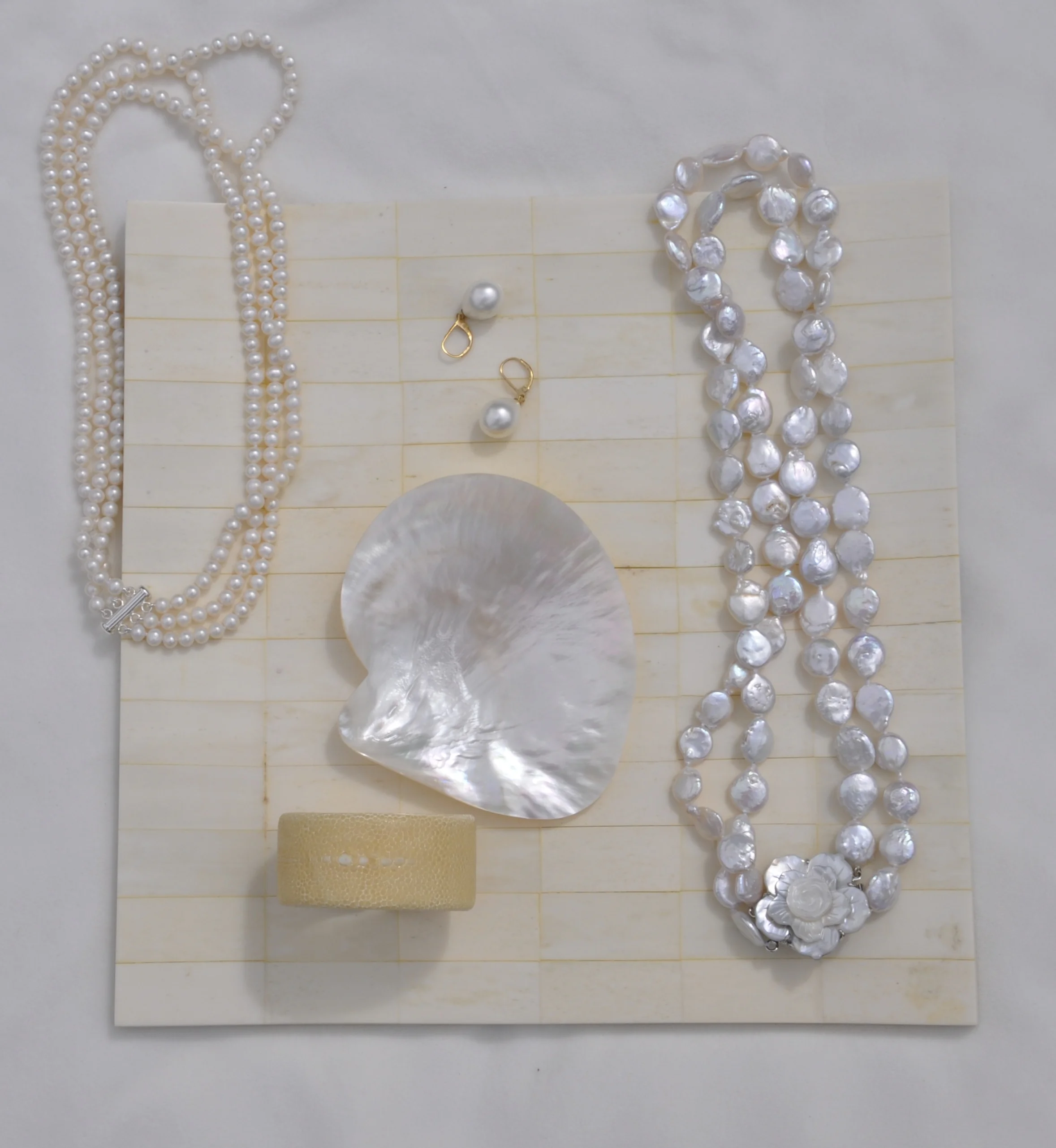 TOP LEFT: 3 strands round white freshwater pearls; CENTER: pearl drop earrings; RIGHT: 2 strand potato freshwater pearls w/ shell clasp; BOTTOM: cream shagreen petit cuff bracelet