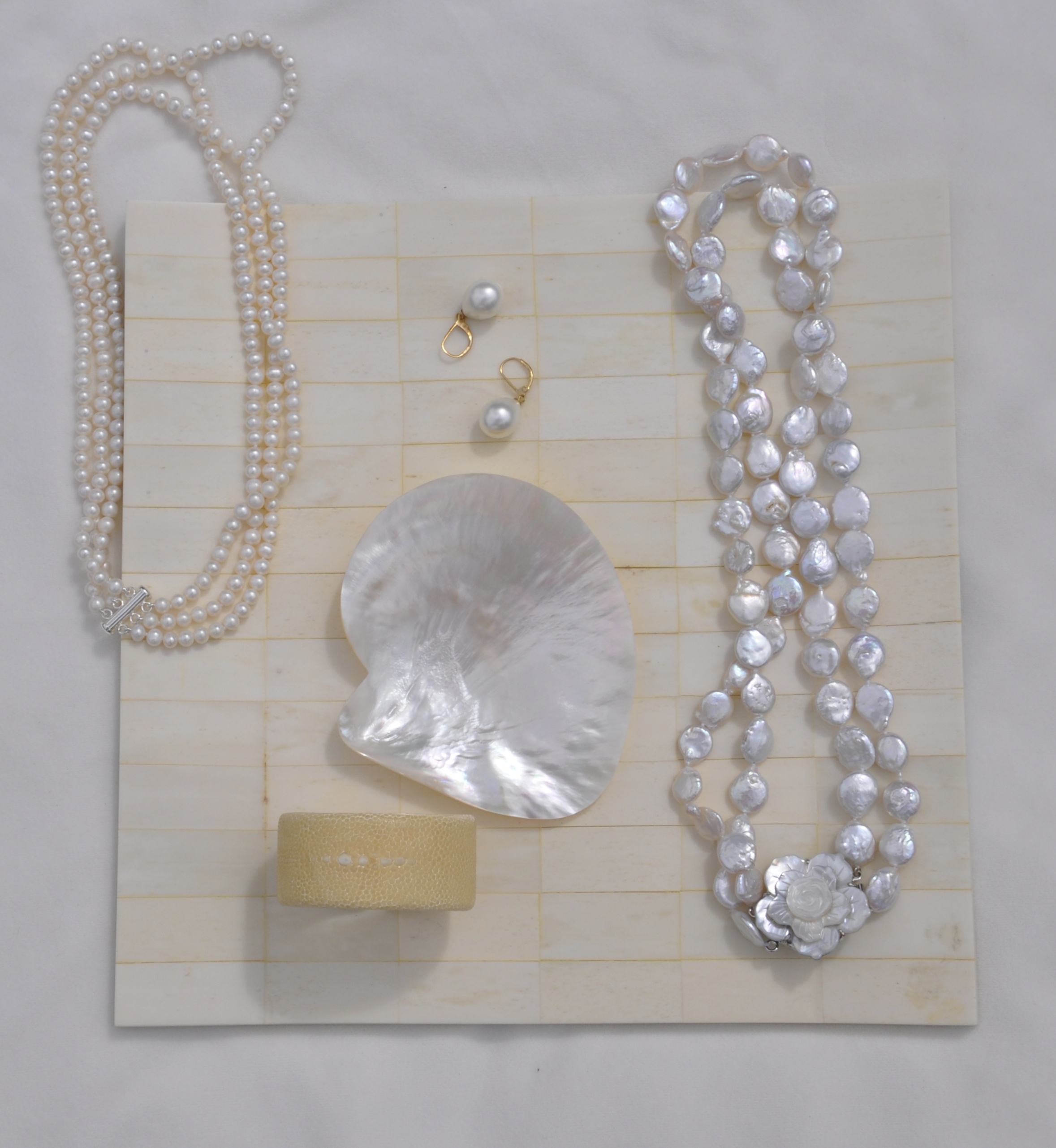 TOP LEFT: 3 strands round white freshwater pearls; CENTER: pearl drop earrings; RIGHT: 2 strand potato freshwater pearls w/ shell clasp; BOTTOM: cream shagreen petit cuff bracelet